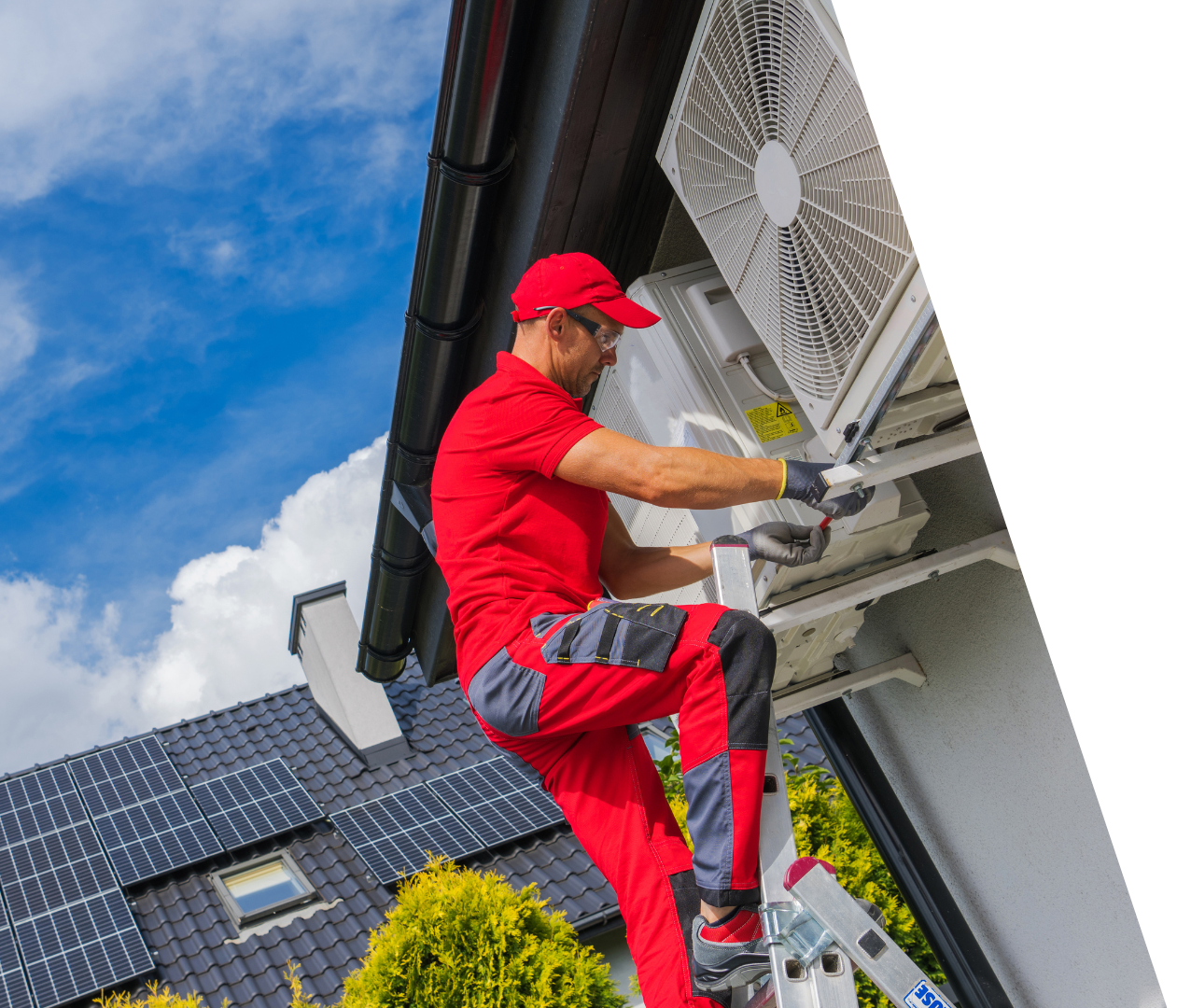 Schedule Service! Technician in red uniform servicing an outdoor air-conditioning unit on a house wall