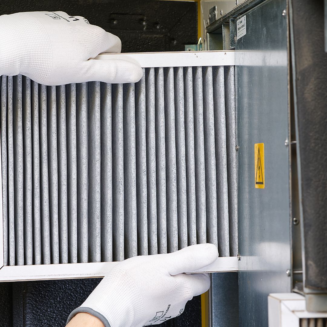 Our Services HVAC Technician installing a new air vent as part of Phil's Heating and Air's Preventative HVAC Maintenance Services