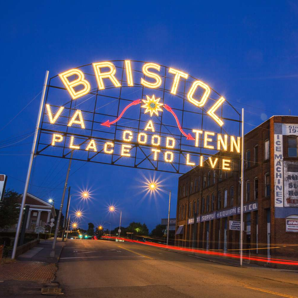 Night view of Bristol, Virginia–Tennessee neon sign reading “A good place to live” over a street