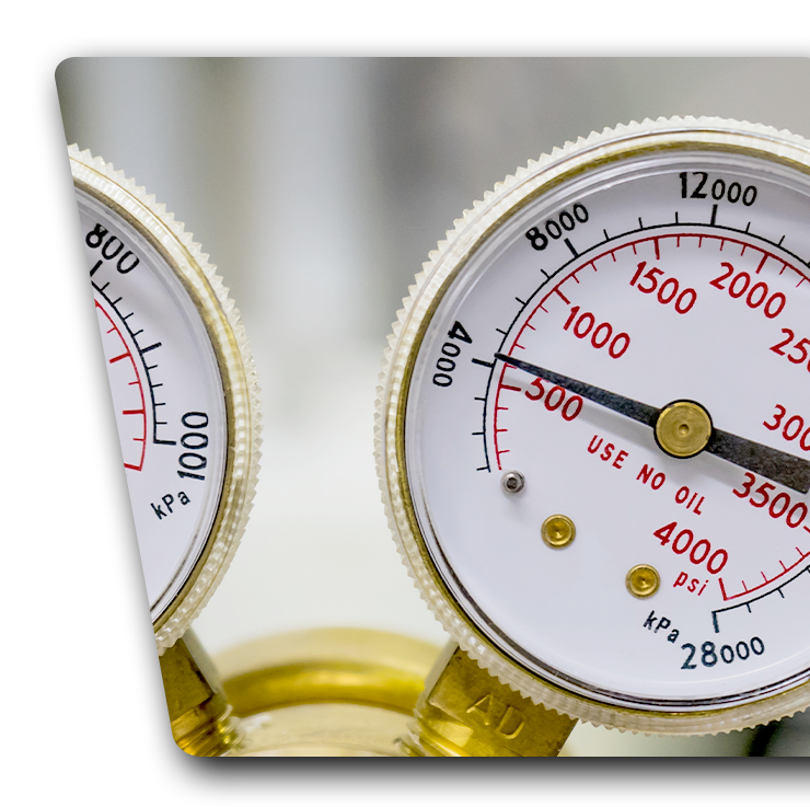 Contact Us Close-up of two white pressure gauges with red and black markings on a brass instrument panel