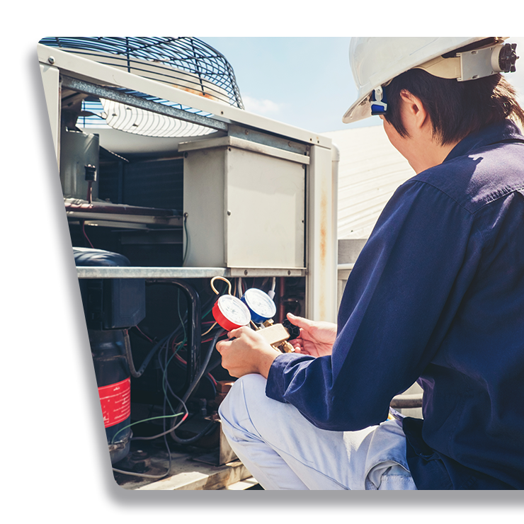 Contact Us Technician inspecting outdoor HVAC unit with gauges attached to the open panel