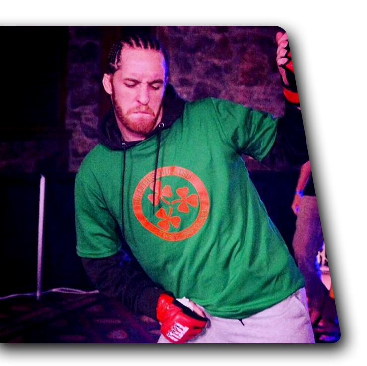 CONTACT US Man in a green T-shirt and red gloves dancing under purple stage lighting