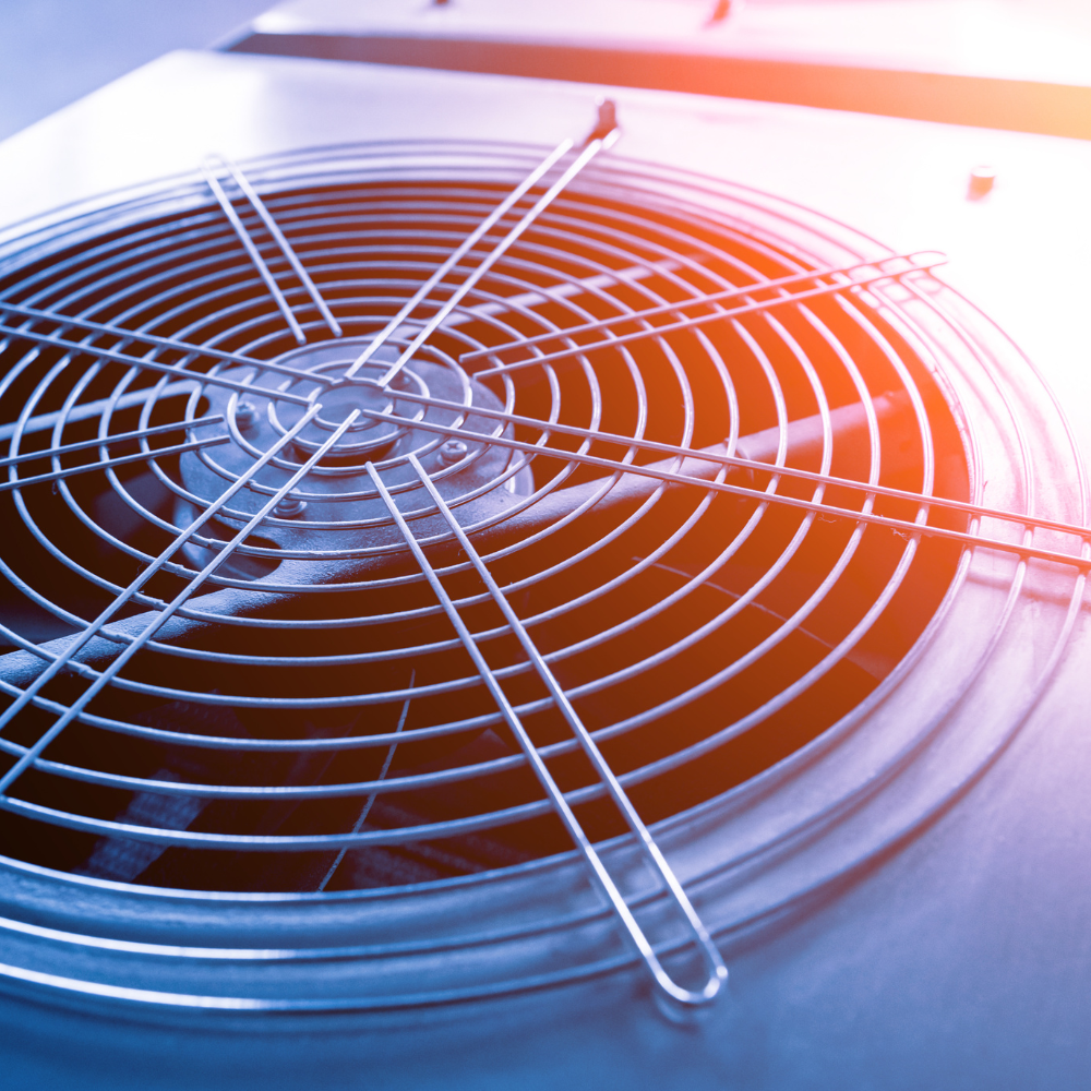 Close-up of a metal ventilation fan grille with blue and orange lighting