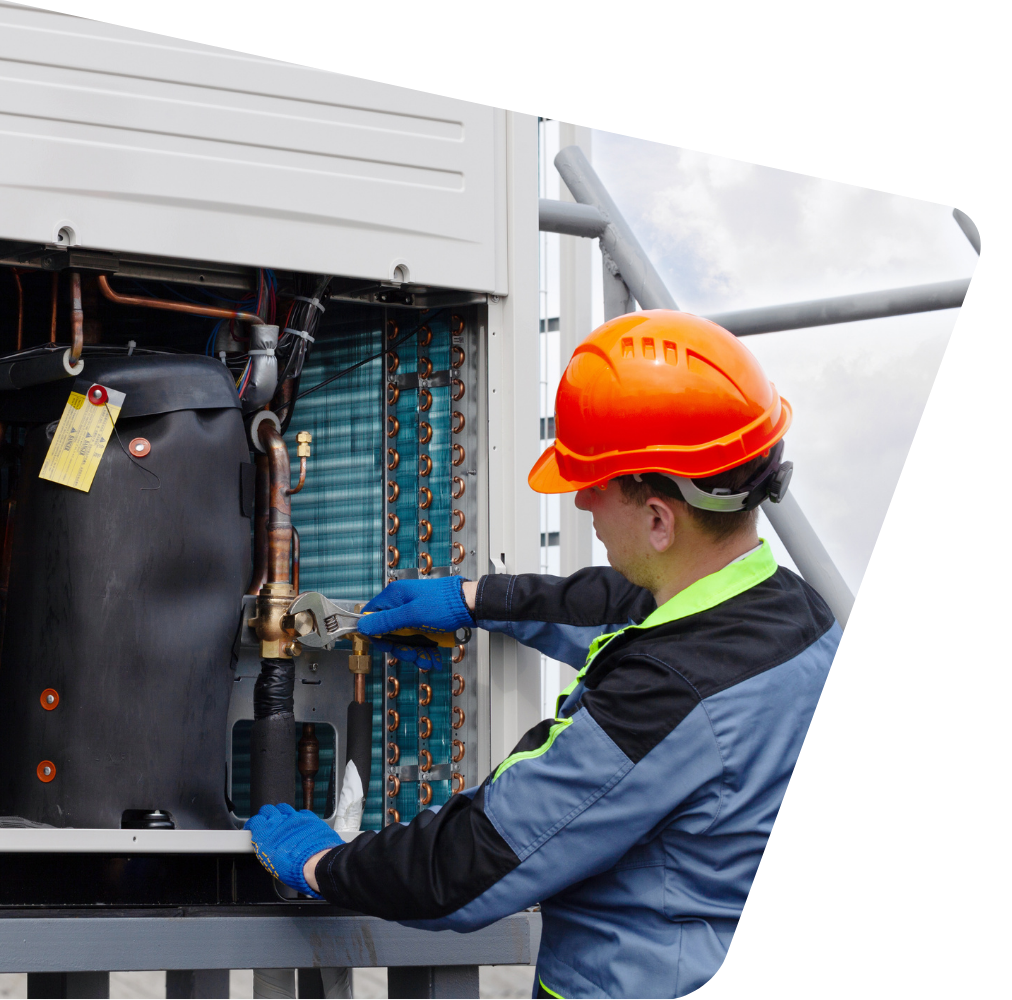 Contact Us Technician in orange hard hat inspecting industrial equipment with blue-gloved hands
