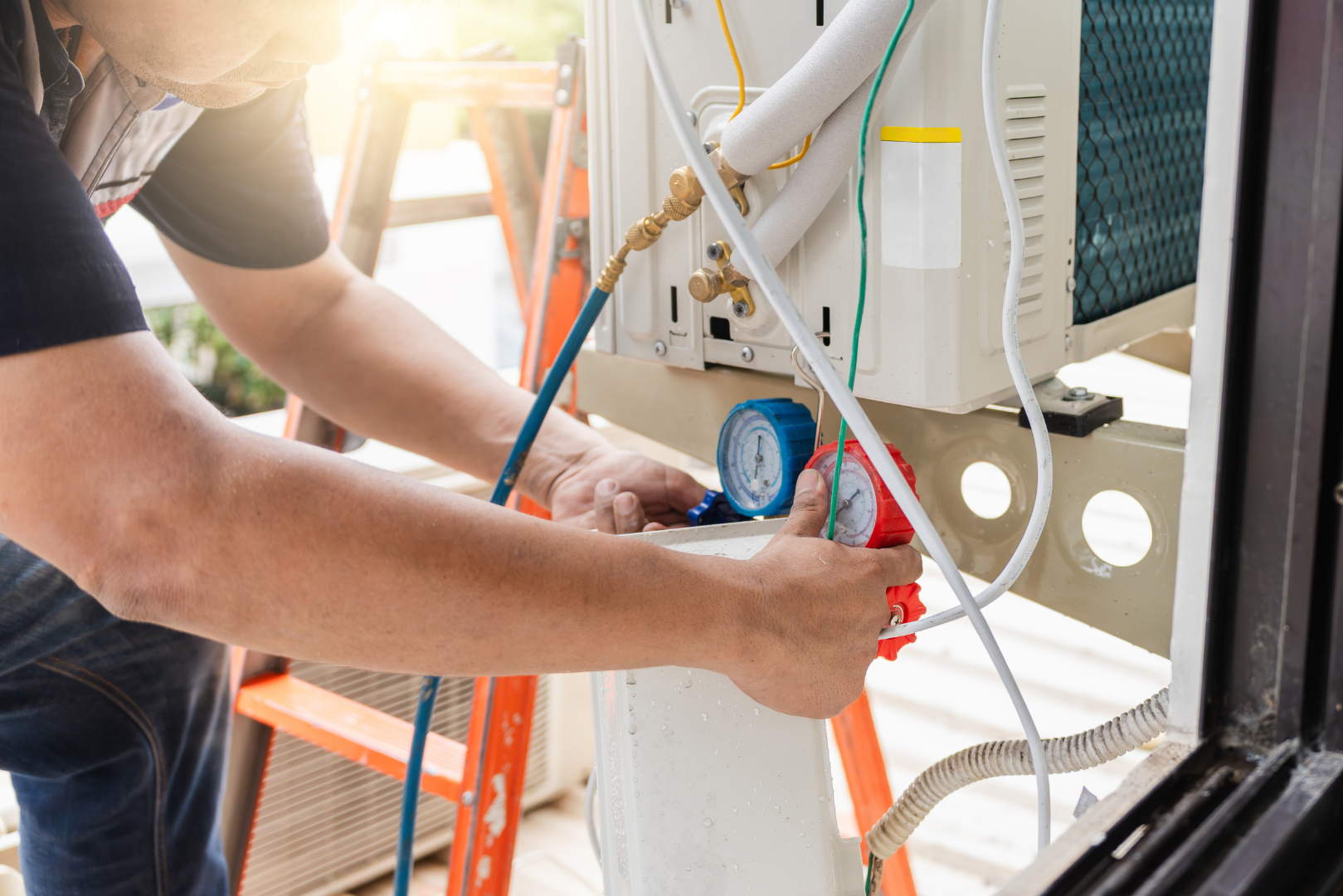 View Our HVAC Services Technician using a pressure gauge and tools to service outdoor HVAC equipment