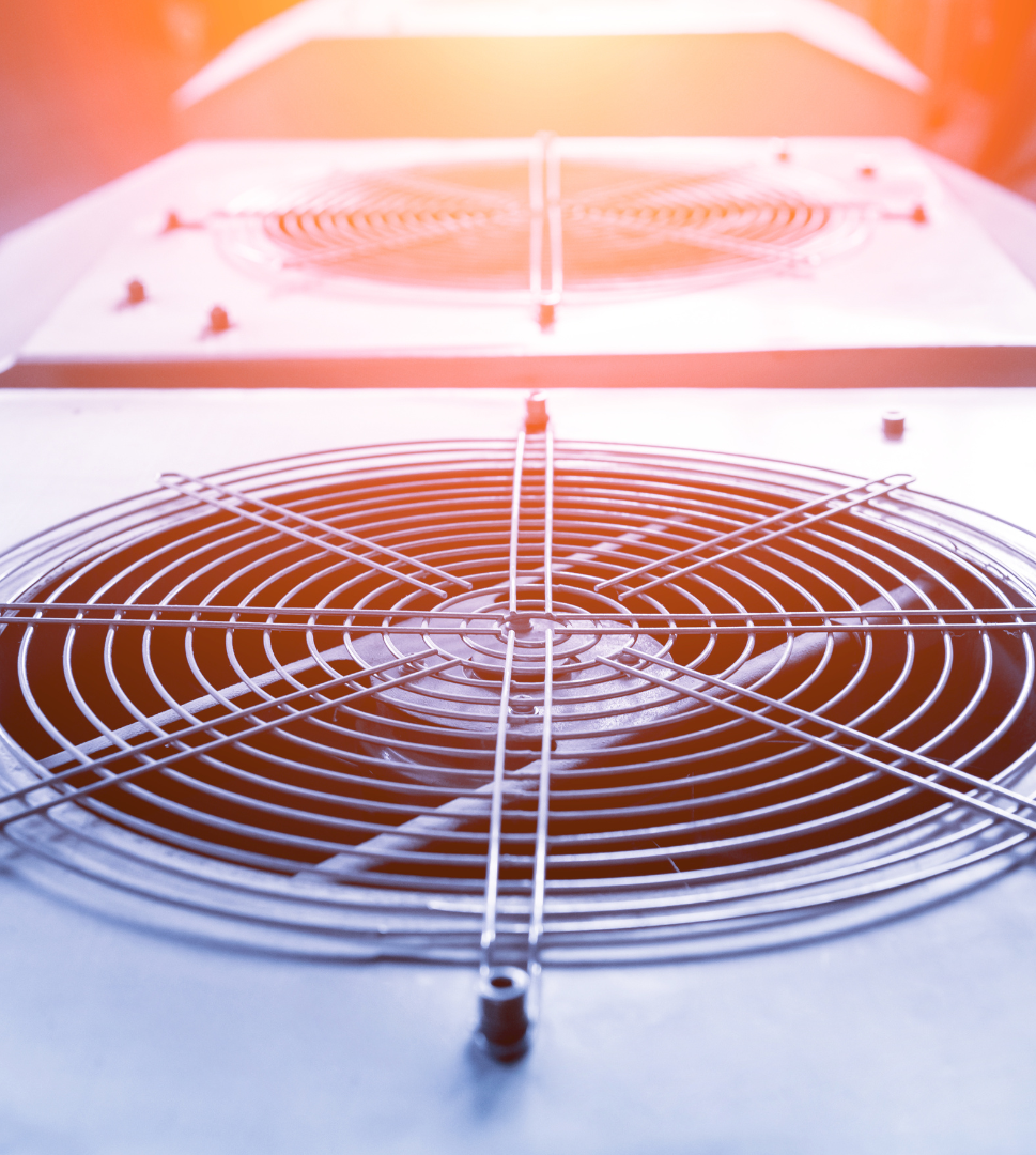 Contact Us! Close-up of a glowing orange industrial fan grille in a machine enclosure