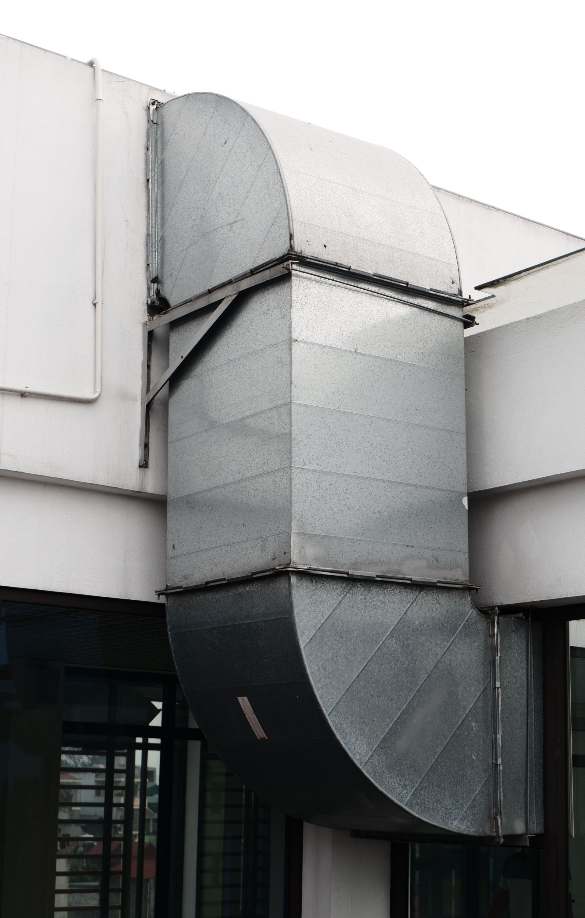Commercial HVAC Repairs & Replacements Metal ventilation duct on the exterior of a building