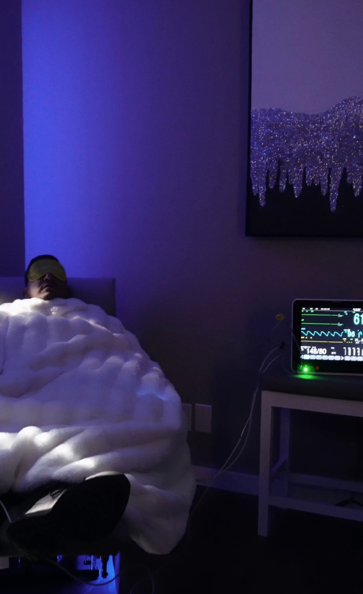 A person is laying in bed in front of a laptop computer.