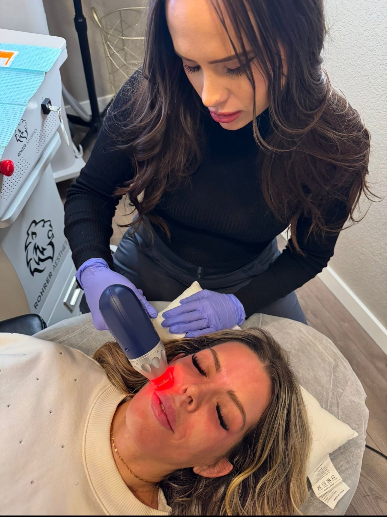 A woman is getting a laser treatment on her face.