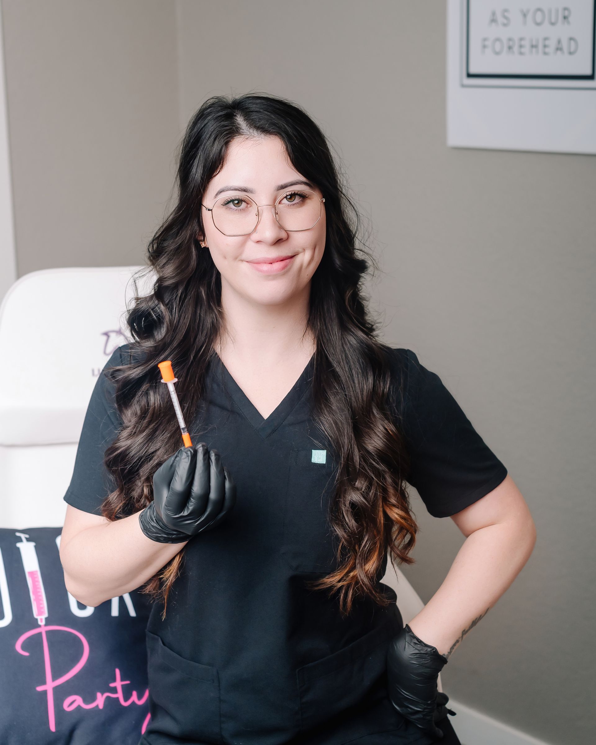 A woman is holding a syringe in her hand and smiling.