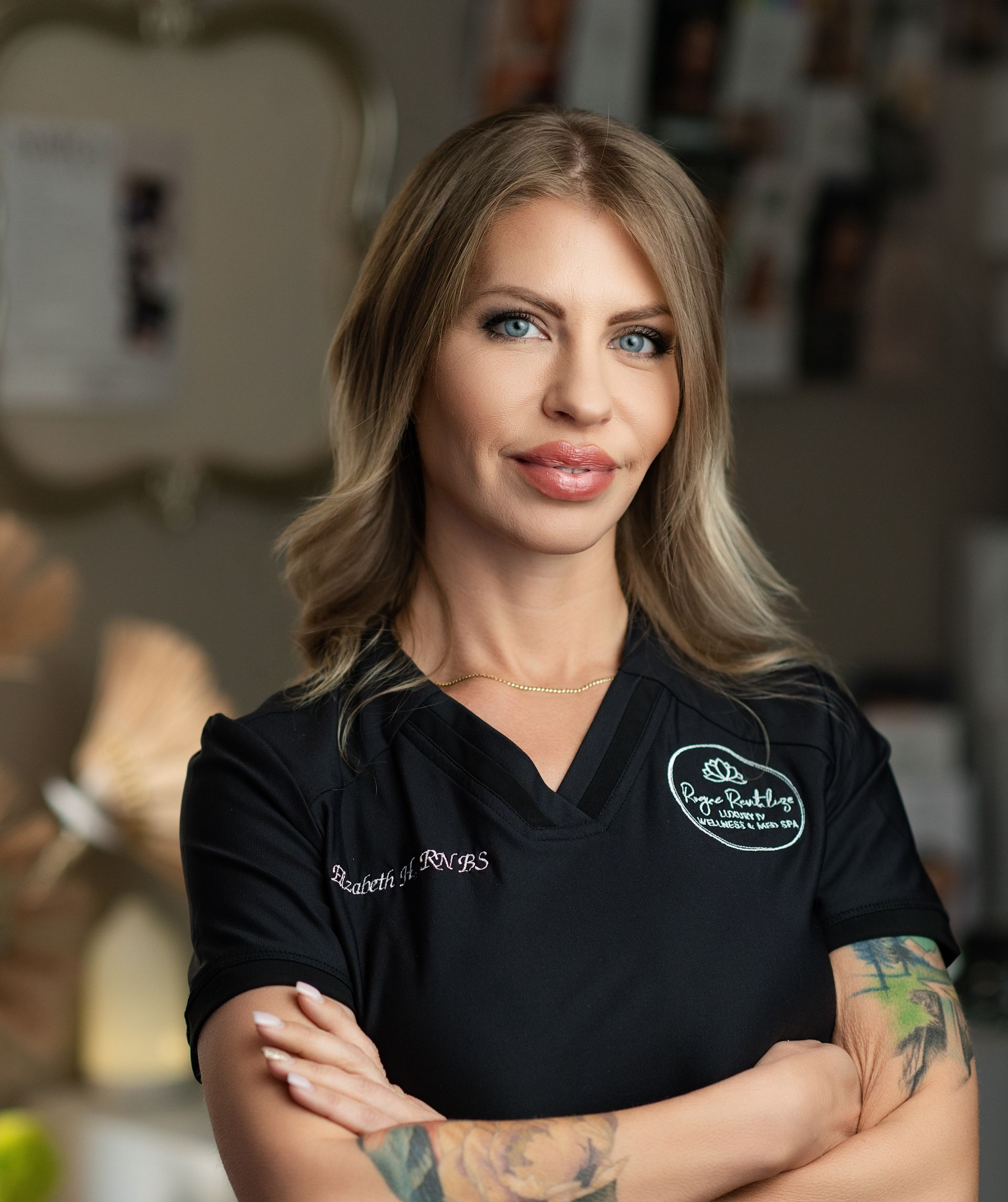 A woman in a black shirt is smiling and standing in a room.