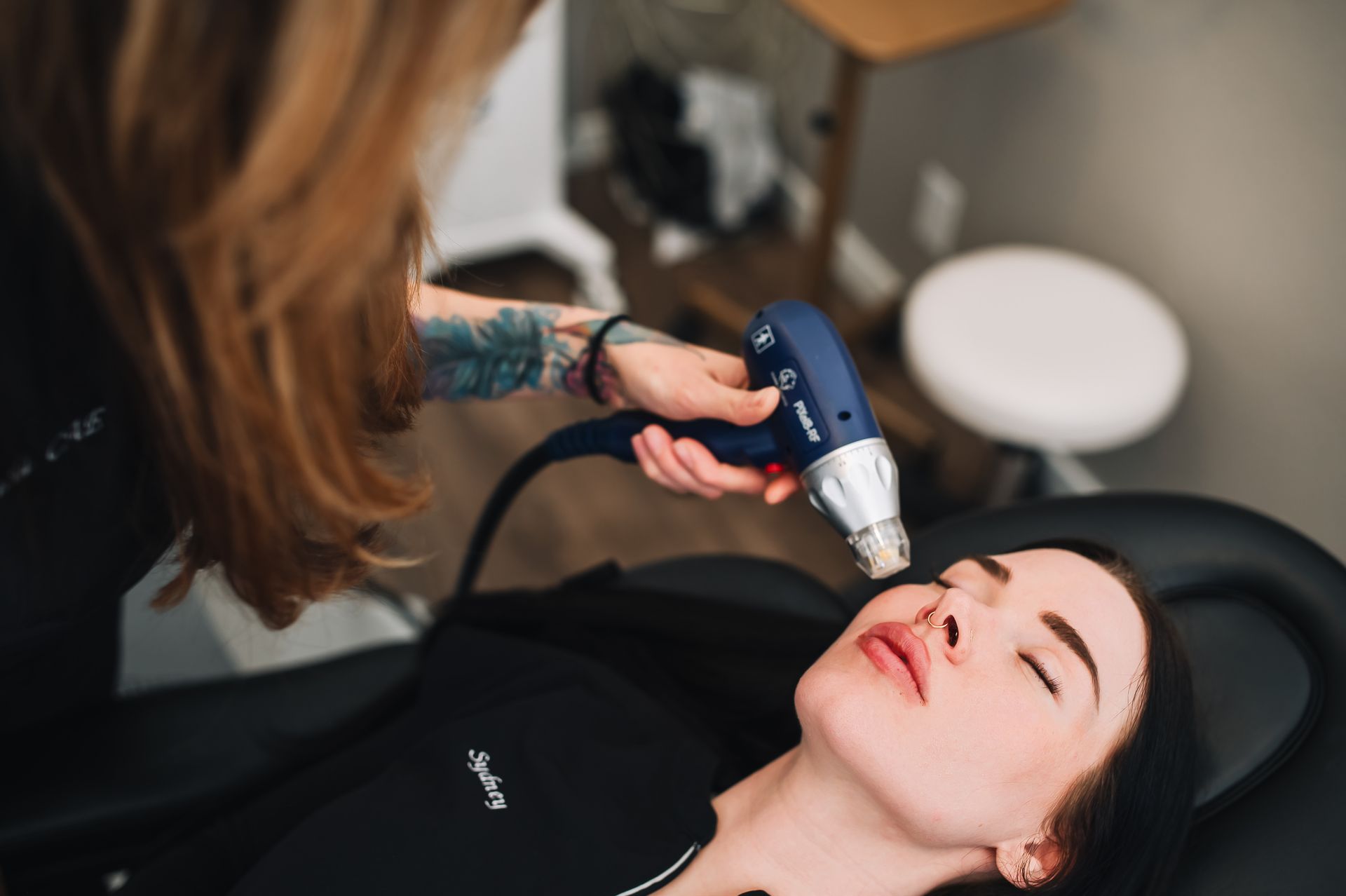 A woman is getting a laser treatment on her face.