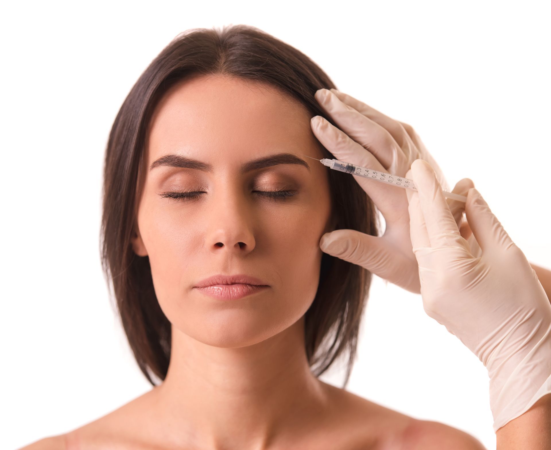 A woman is getting a botox injection in her forehead.