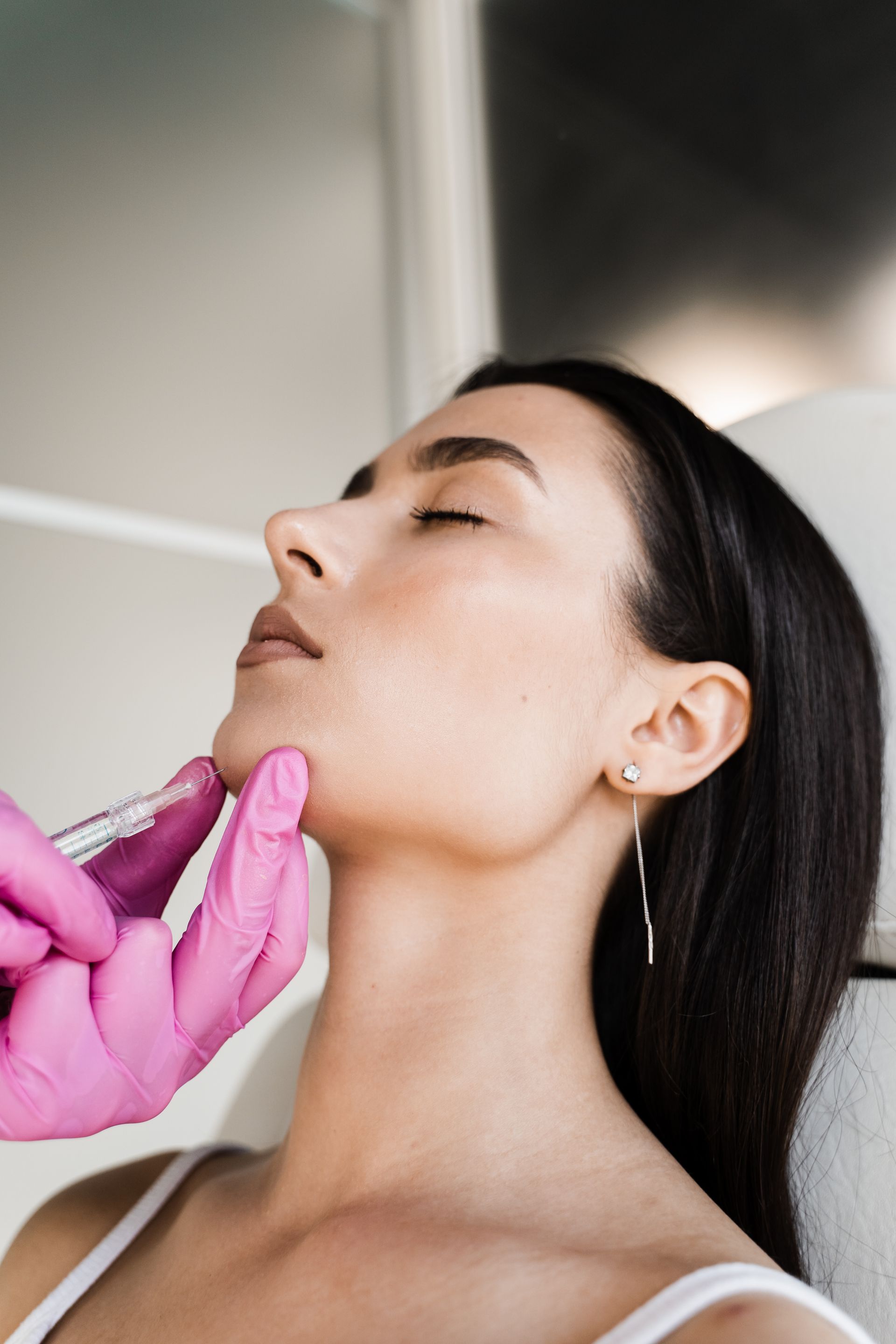 A woman is getting a botox injection in her face.