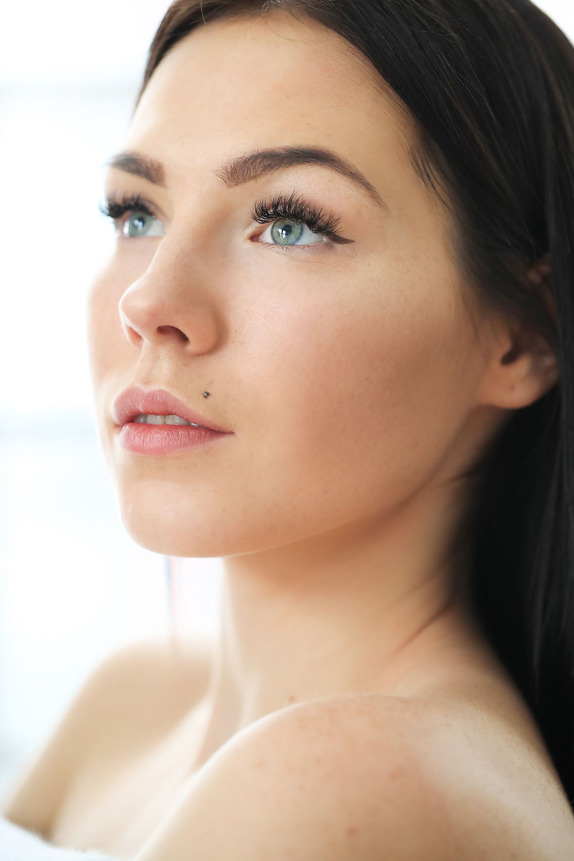 A close up of a woman 's face with long hair and blue eyes.