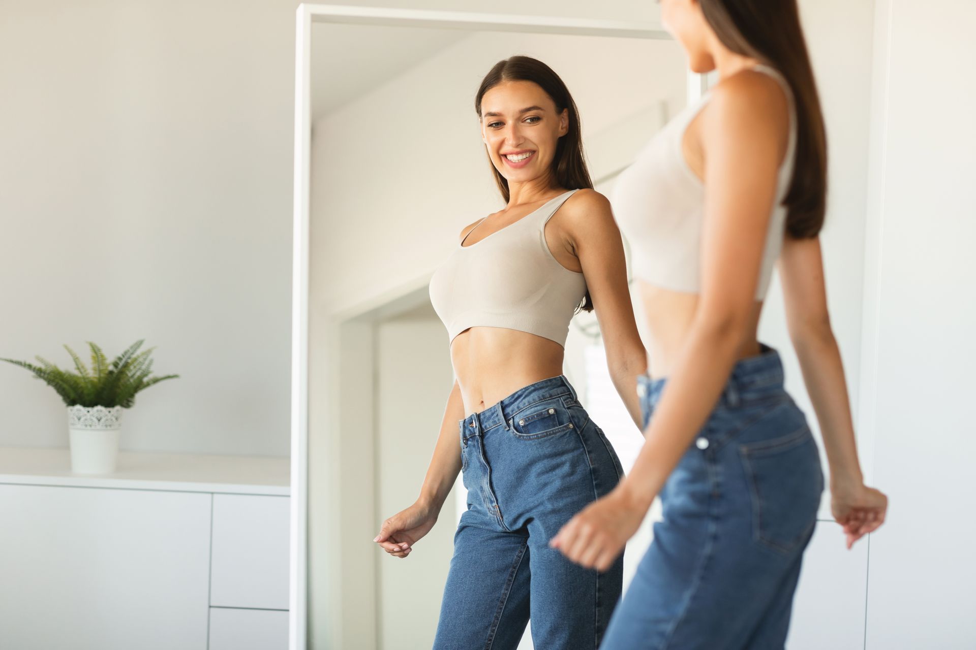 A woman is looking at her reflection in a mirror.