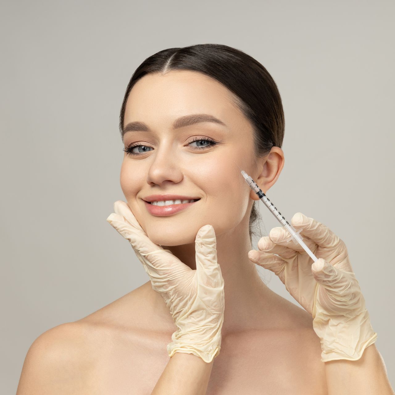 A woman is getting a botox injection in her face.
