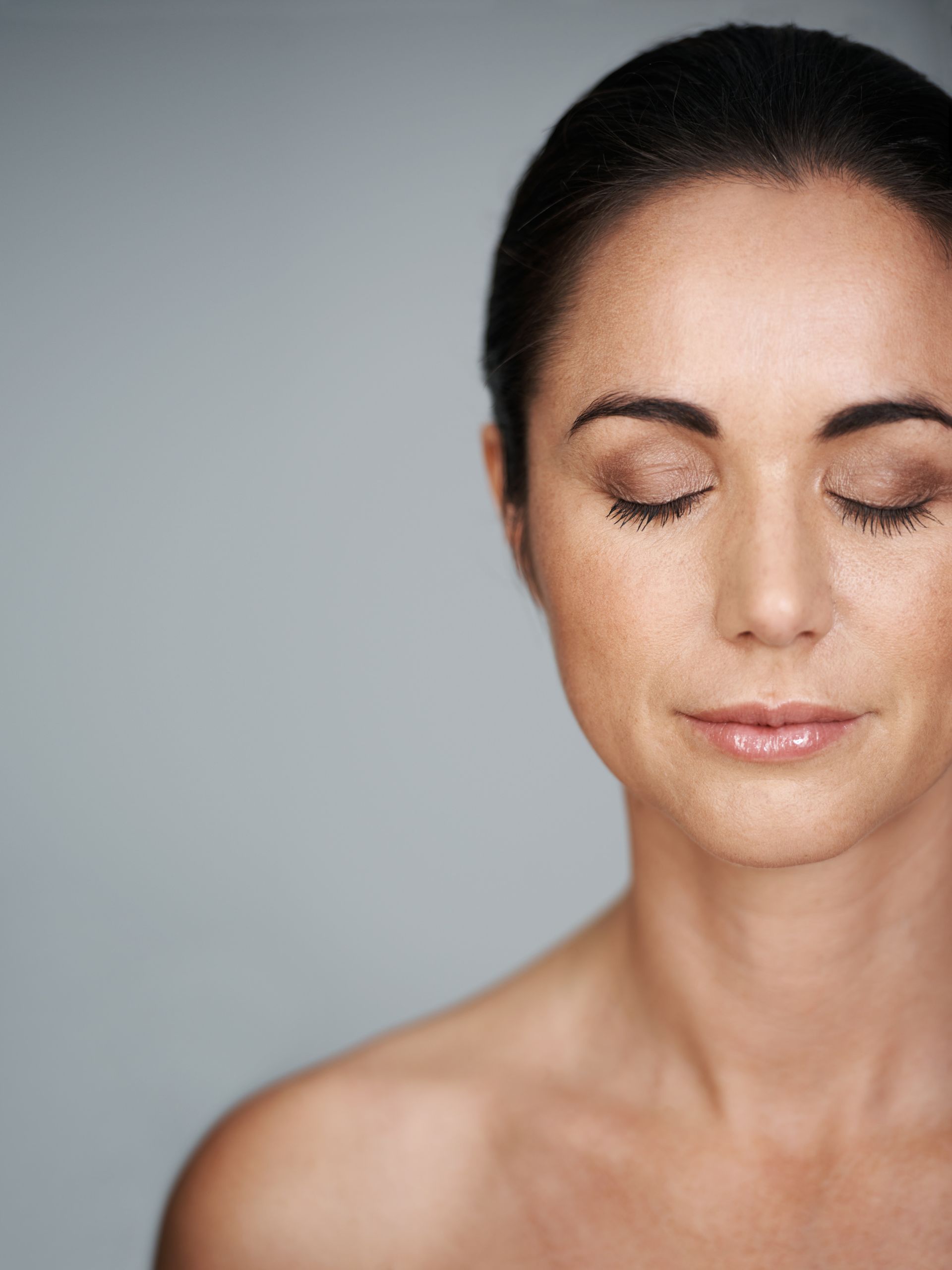 A close up of a woman 's face with her eyes closed.