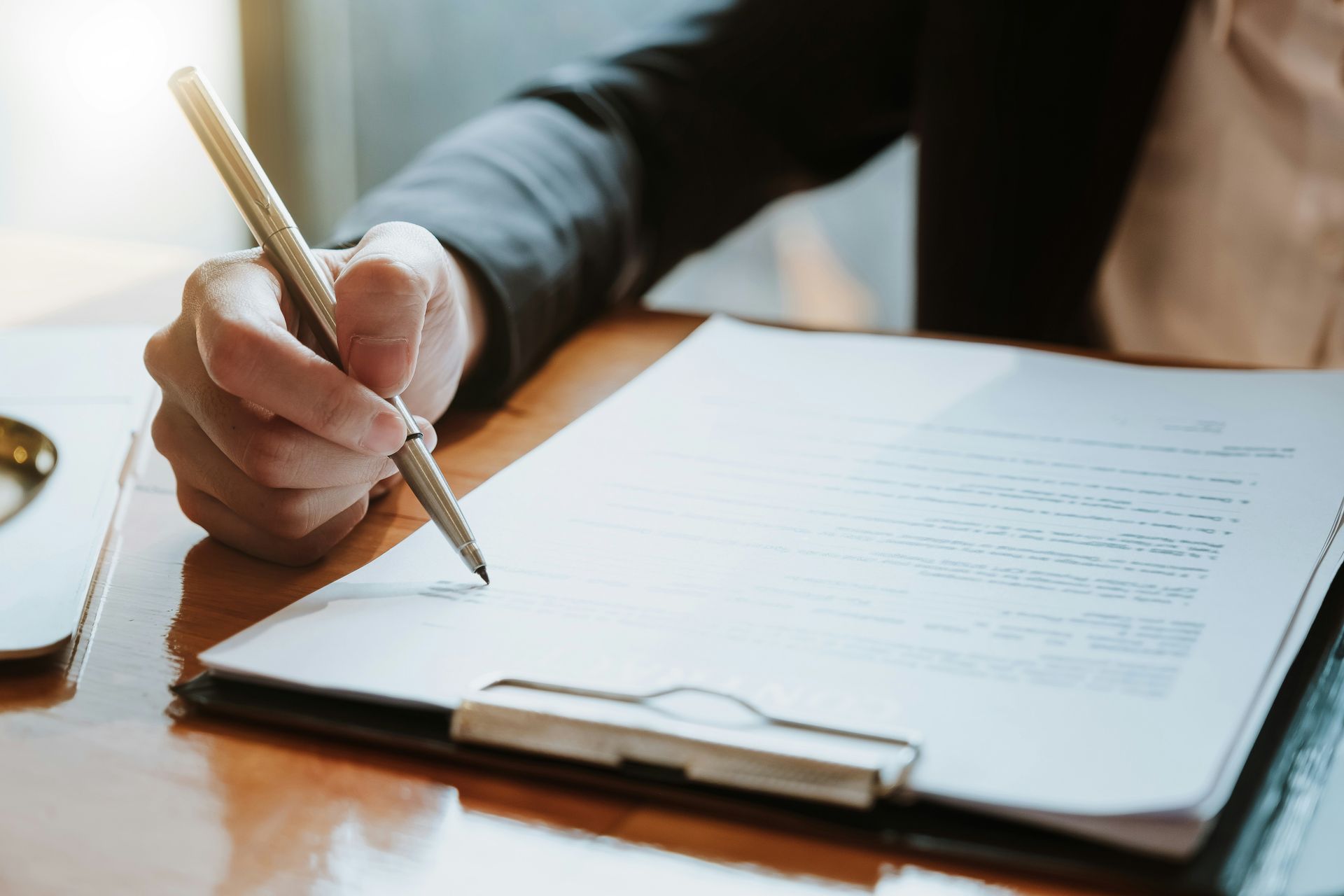 A person is writing on a clipboard with a pen.