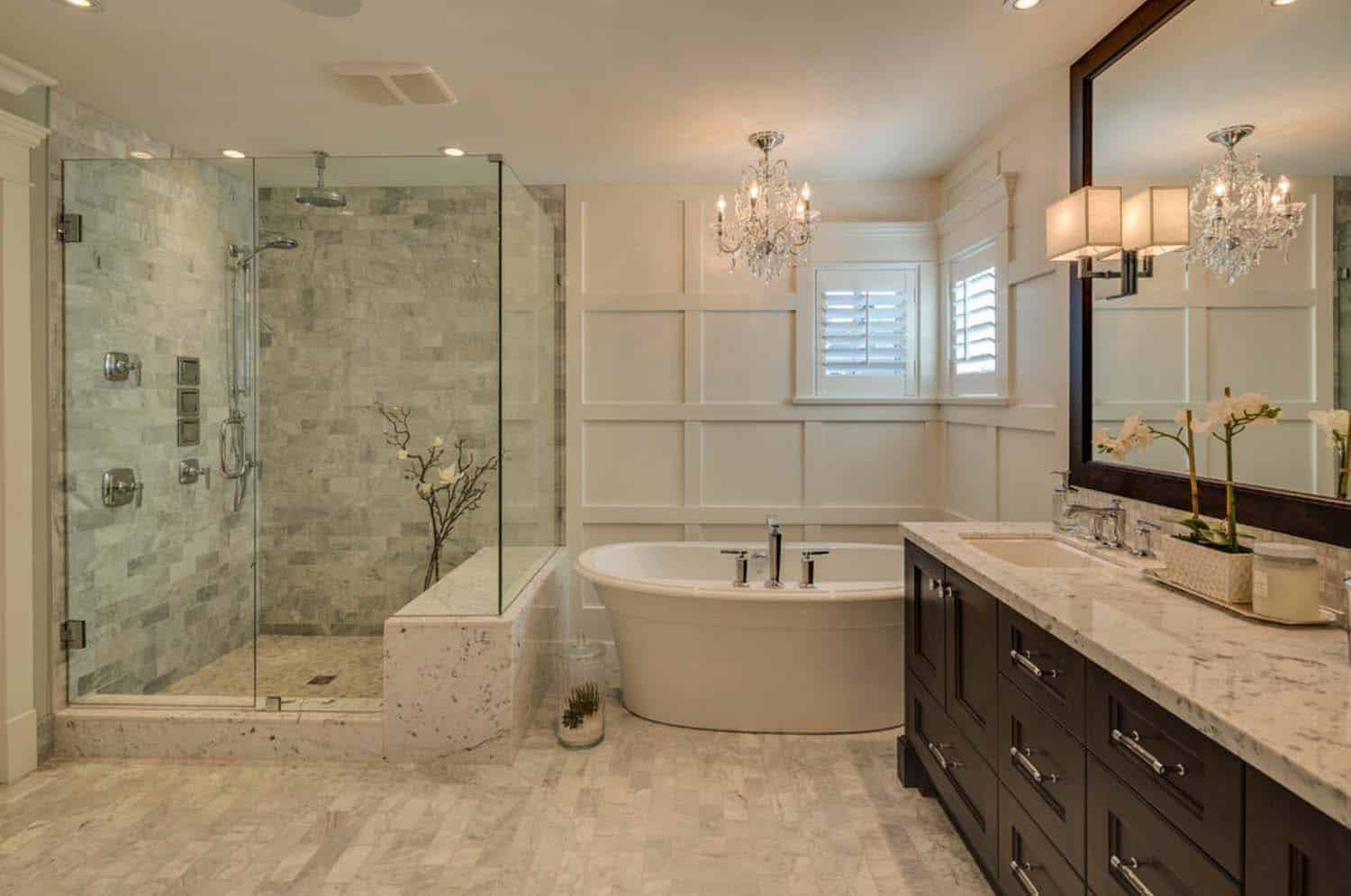 Bathroom with copper bathtub against a stone wall, glass shower, wooden vanity, and tiled floor.