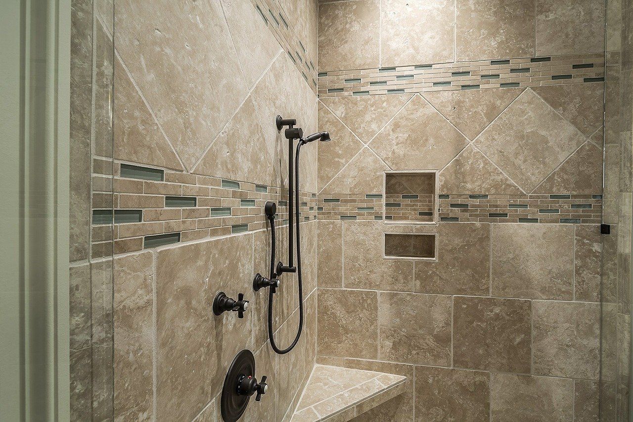 Bathroom with white shower and toilet, wood-look floor tiles, white vanity, and light blue walls.