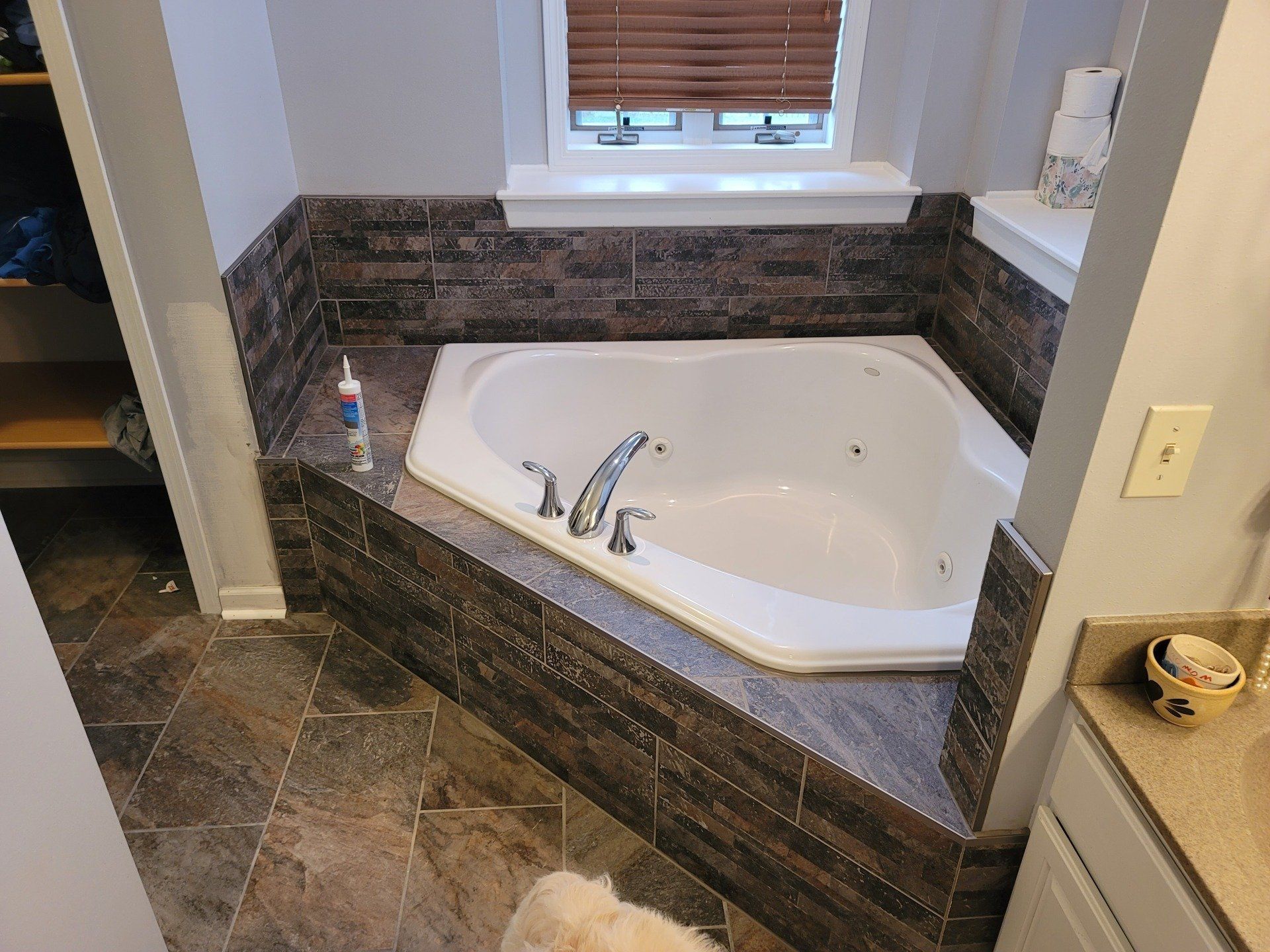 A person installing floor tiles, using leveling clips to ensure a flush finish.