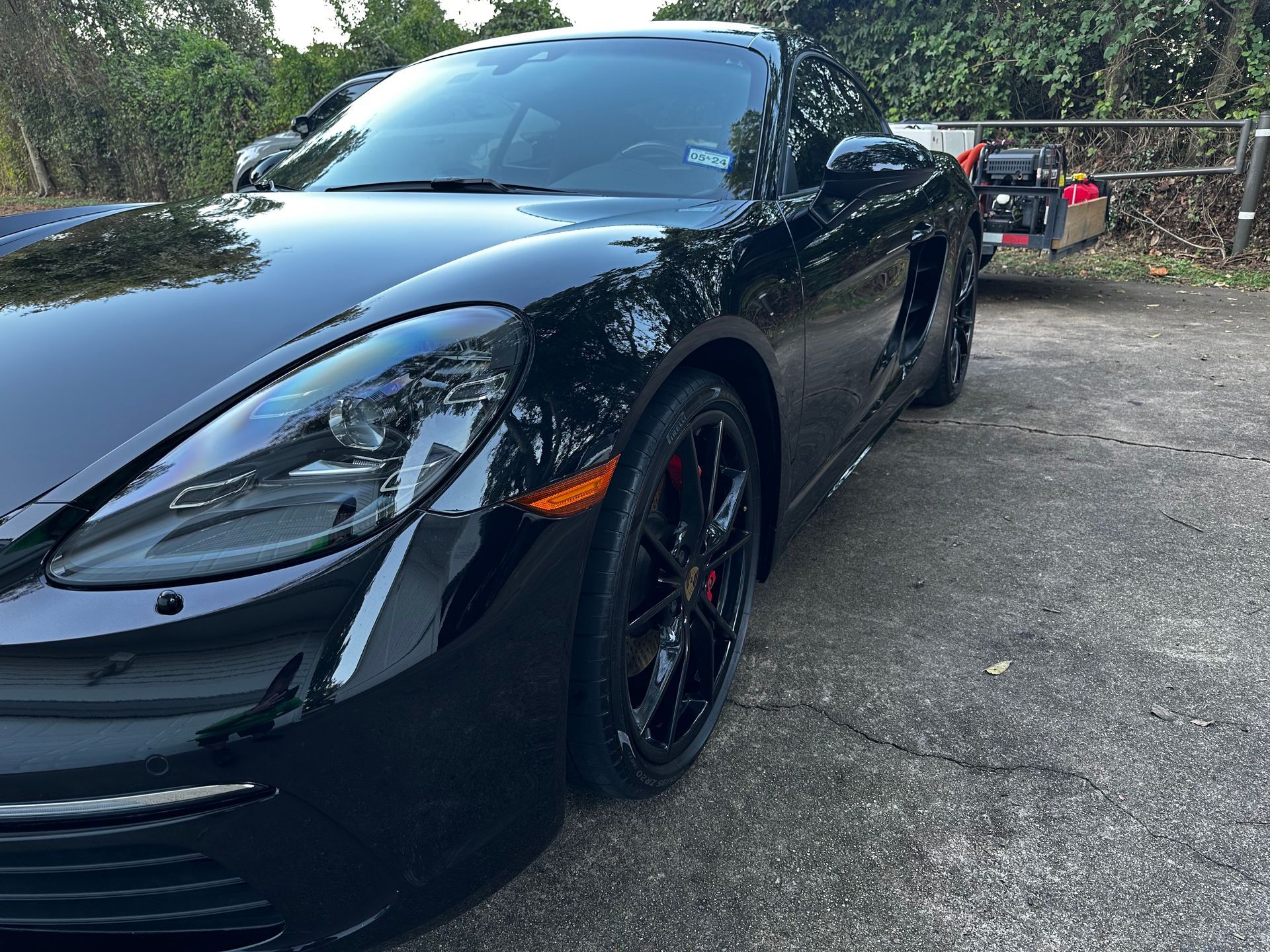 A black sports car is parked in a parking lot.