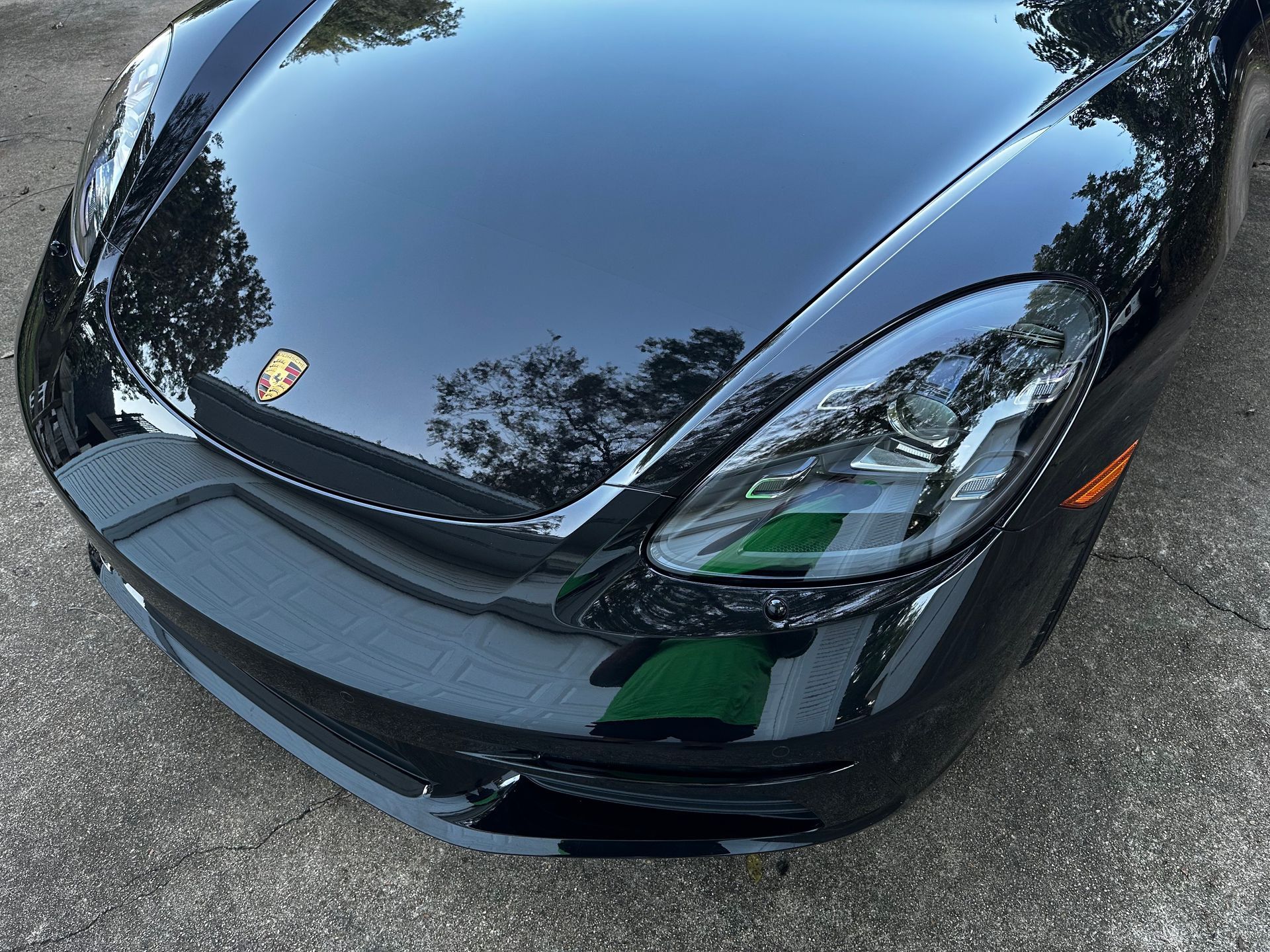 A black sports car is parked in a parking lot.