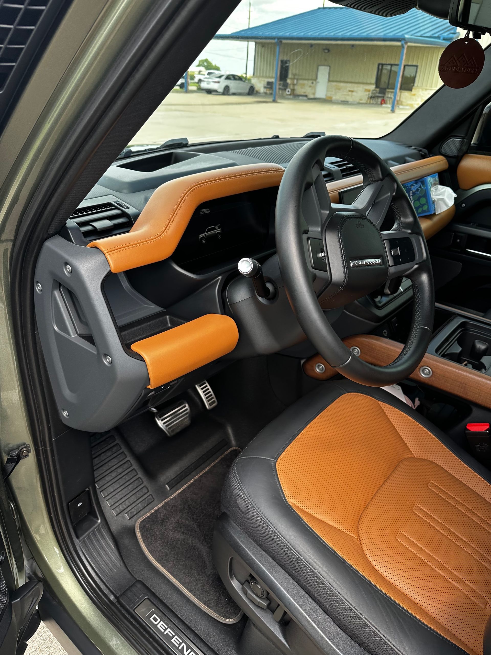 The interior of a red sports car with a black steering wheel