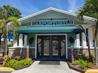Tarpon Turtle restaurant entrance with green awning and blue double doors under a sunny sky