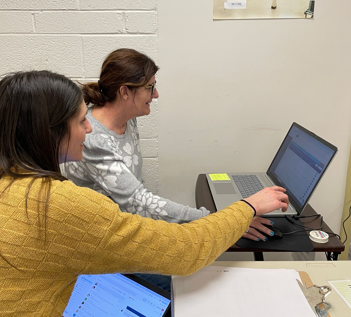 Two female volunteers entering data on a computer at the church's food pantry.
