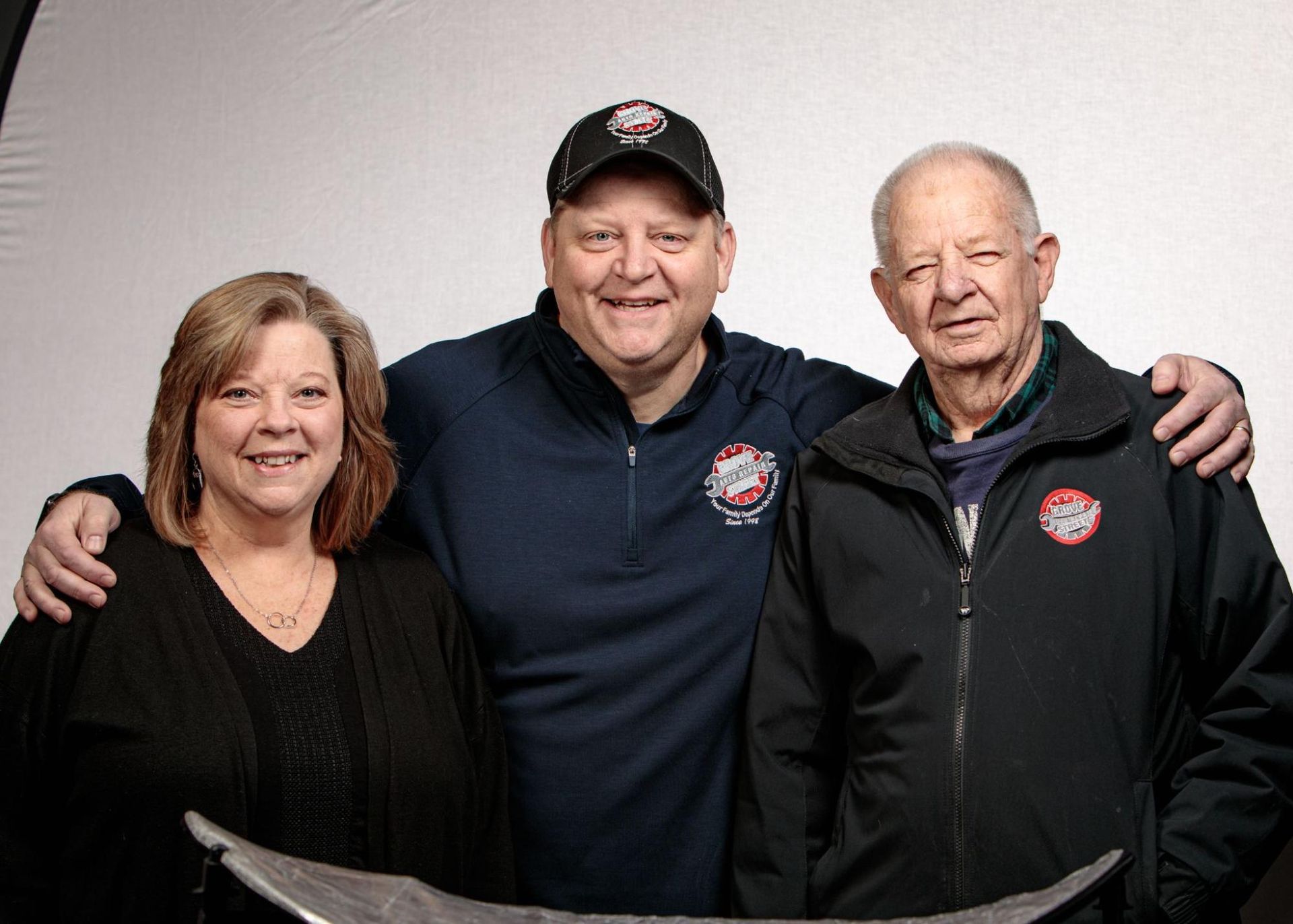 two men and a woman are posing for a picture together .