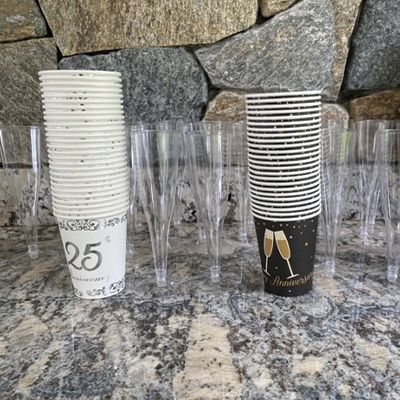 a stack of paper cups and plastic glasses on a counter .