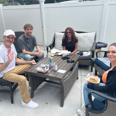 a group of people are sitting around a table on a patio