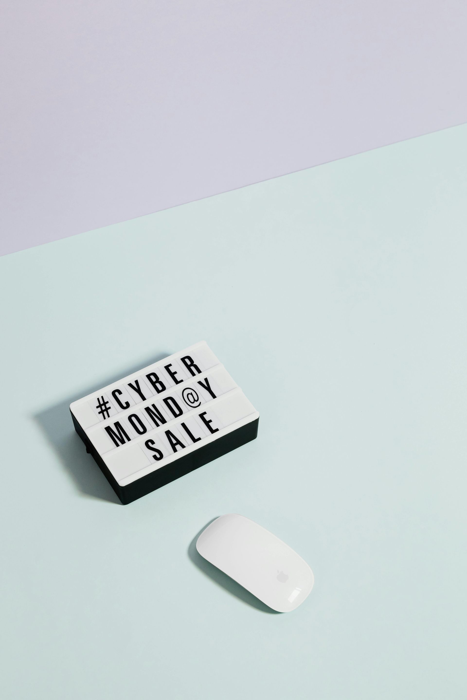 A computer mouse is sitting next to a remote control that says cyber monday sale
