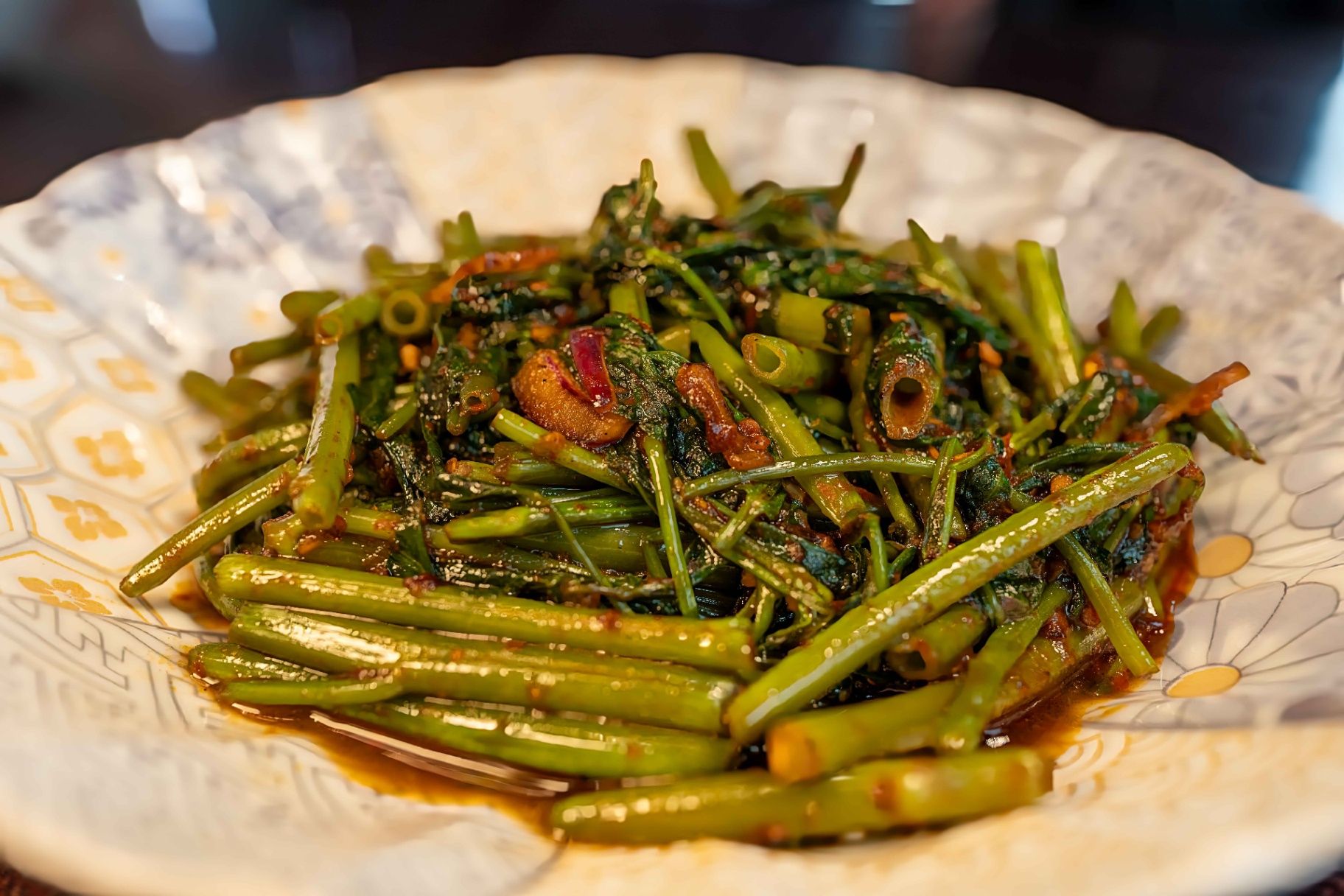 Plate of stir-fried green beans with red chili flakes and herbs