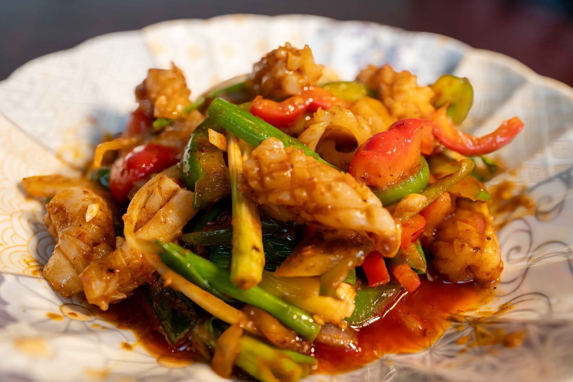 Stir-fried chicken with colorful vegetables in a saucy dish served on a white plate