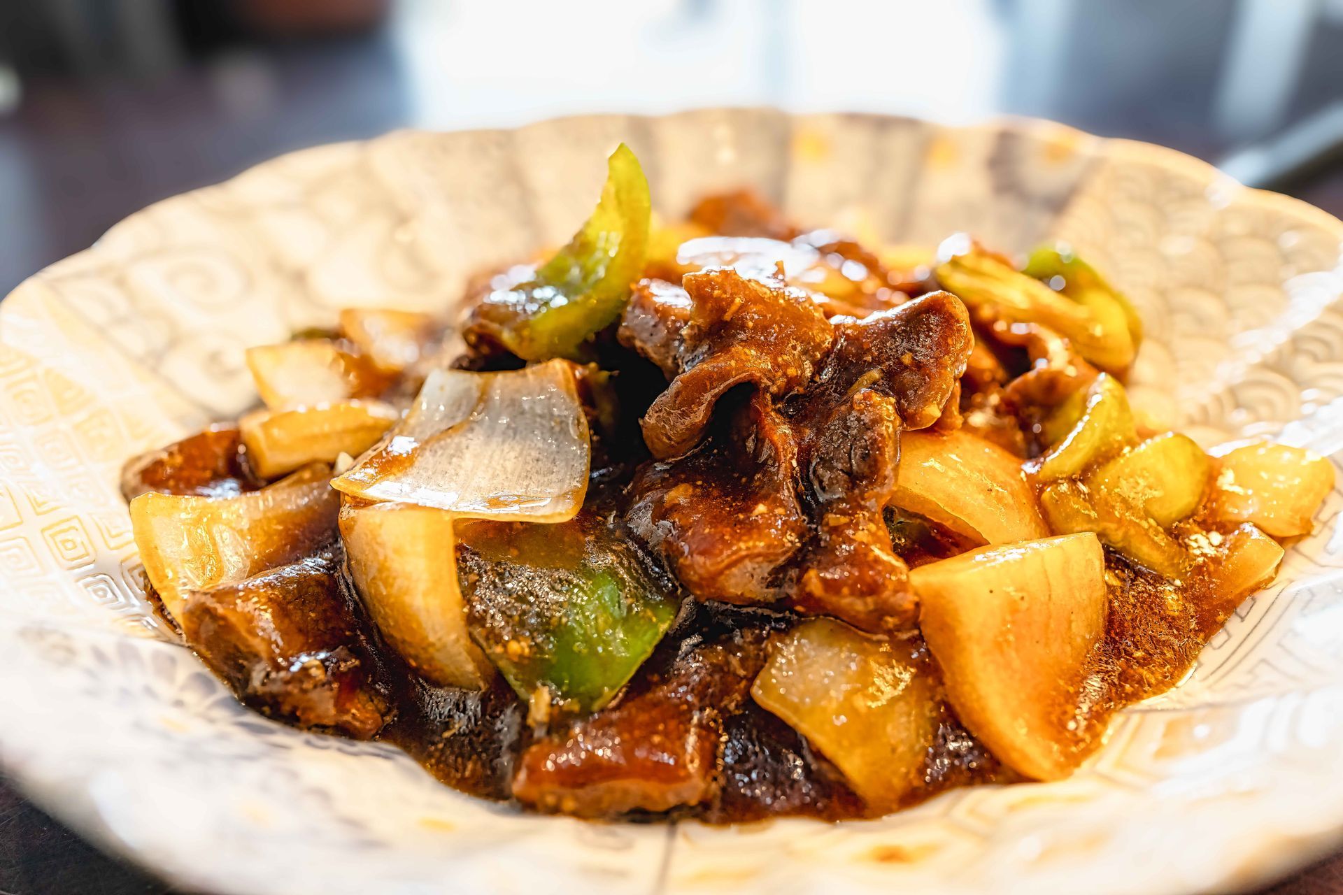 Stir-fried vegetables and meat in a brown sauce served on a white plate
