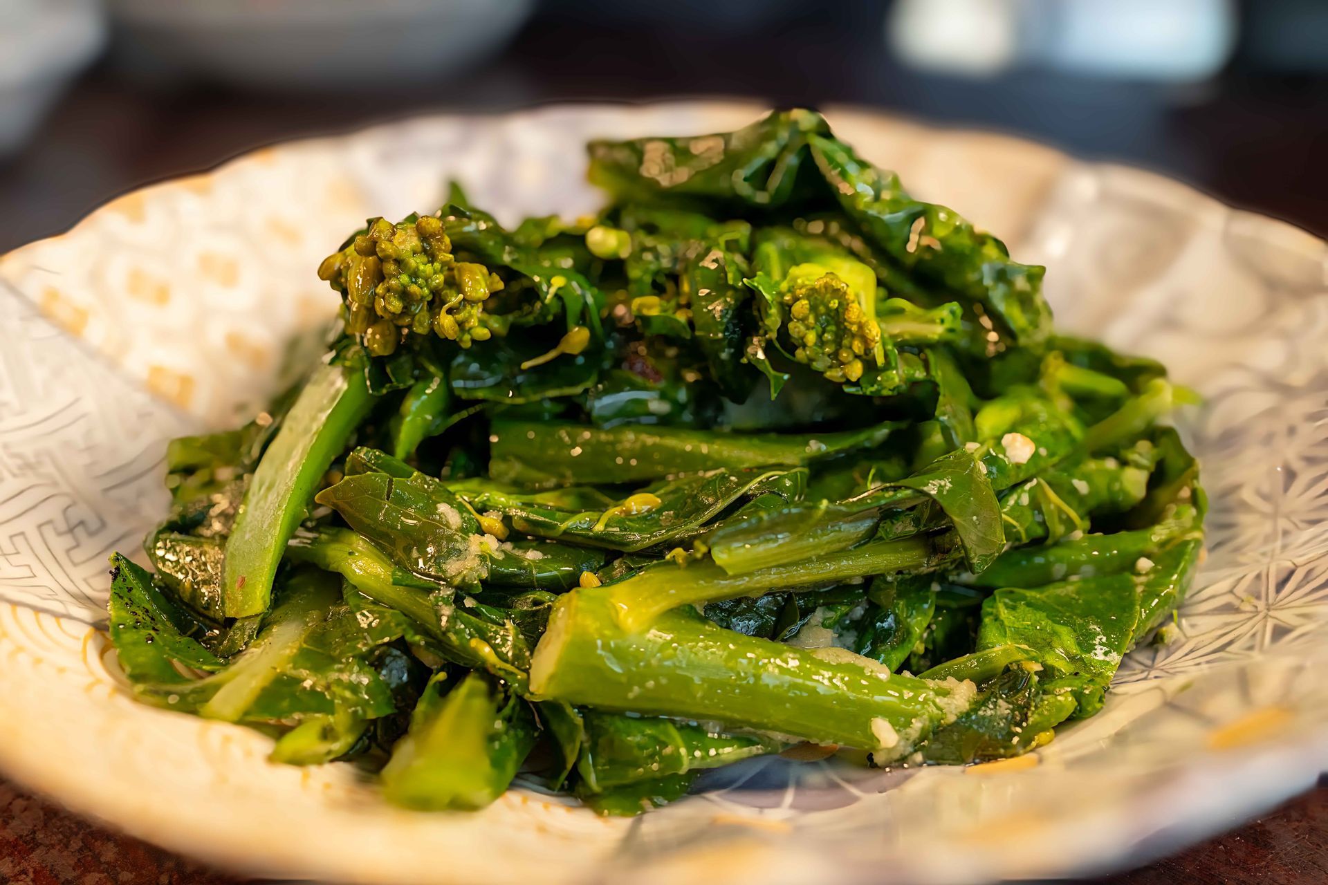 Plate of glossy green cooked vegetables on a patterned dish