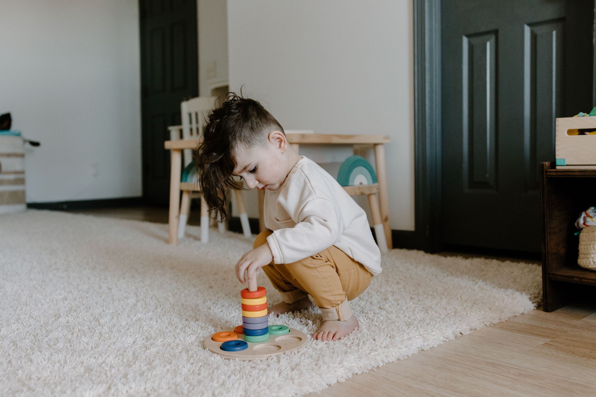 Young child in blue shirt pulling the toilet flush lever.