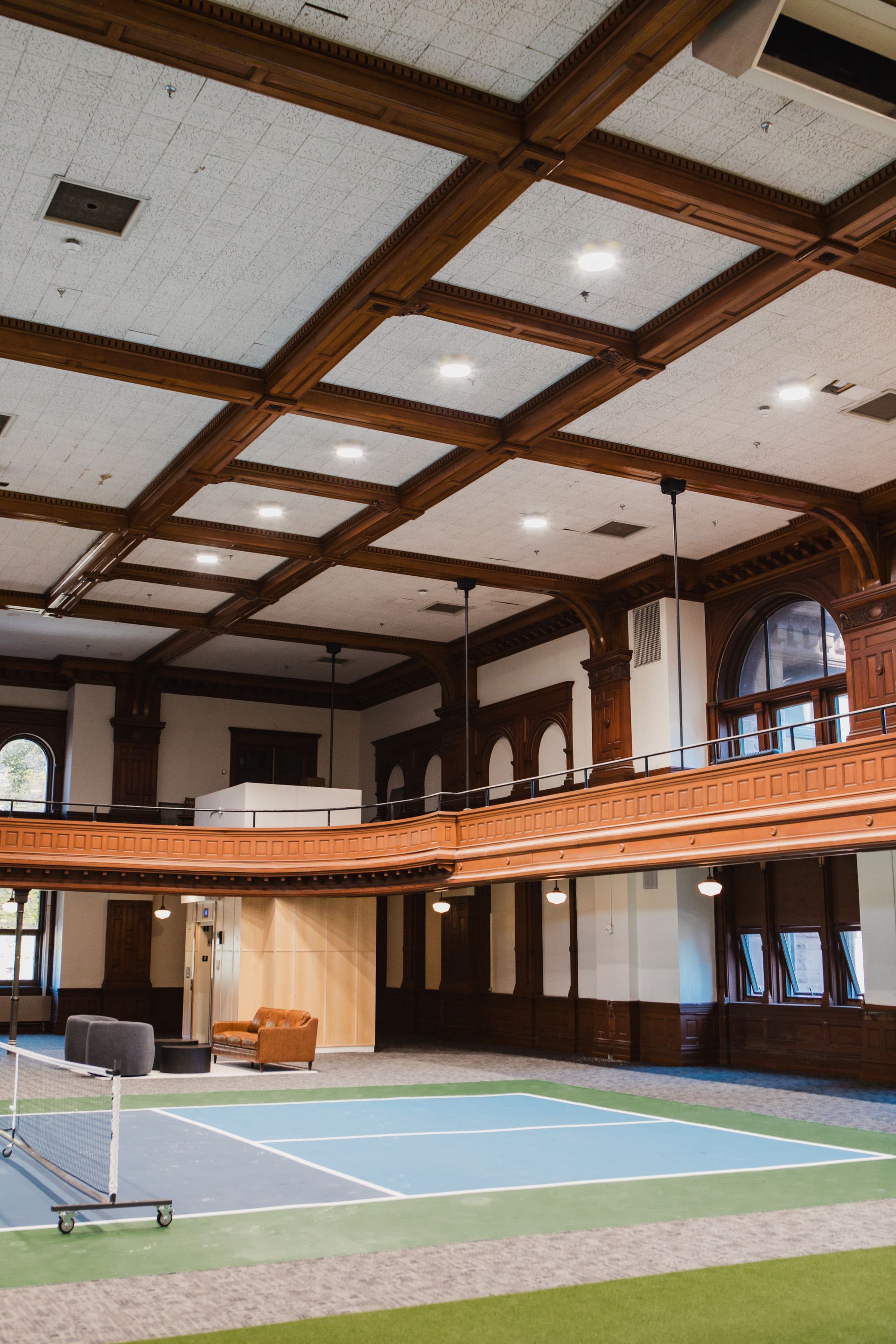 Indoor sports court with wood paneled walls, a balcony, and a coffered ceiling at Zenith Apartments in Duluth, MN.
