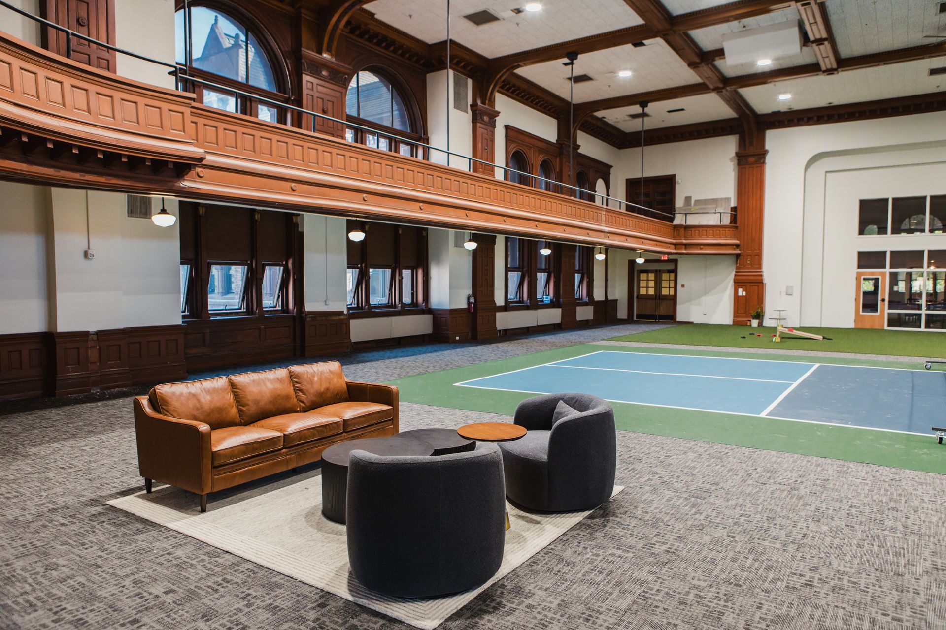 Indoor lounge area with couches, chairs, and a small playing field. Wood and brick architecture, neutral colors at Zenith Apartments in Duluth, MN.