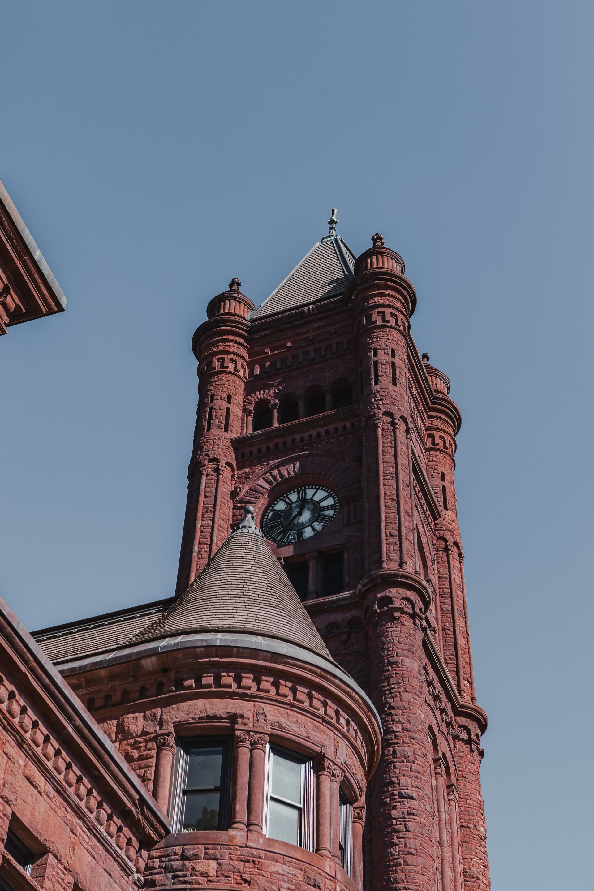Red brick clock tower against a clear blue sky at Zenith Apartments in Duluth, MN.