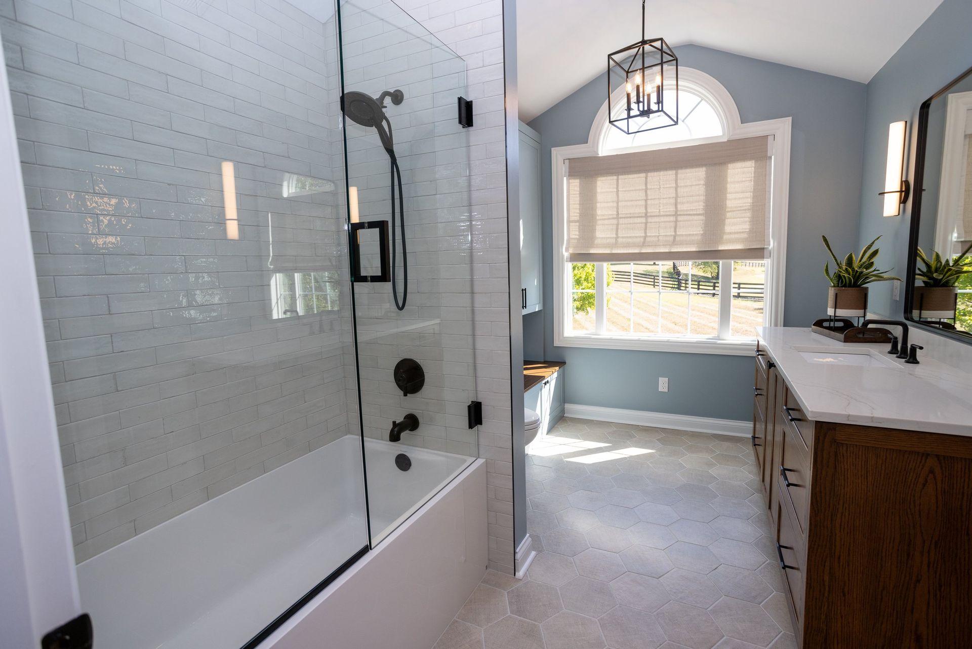A bathroom with a bathtub , sink , and shower.