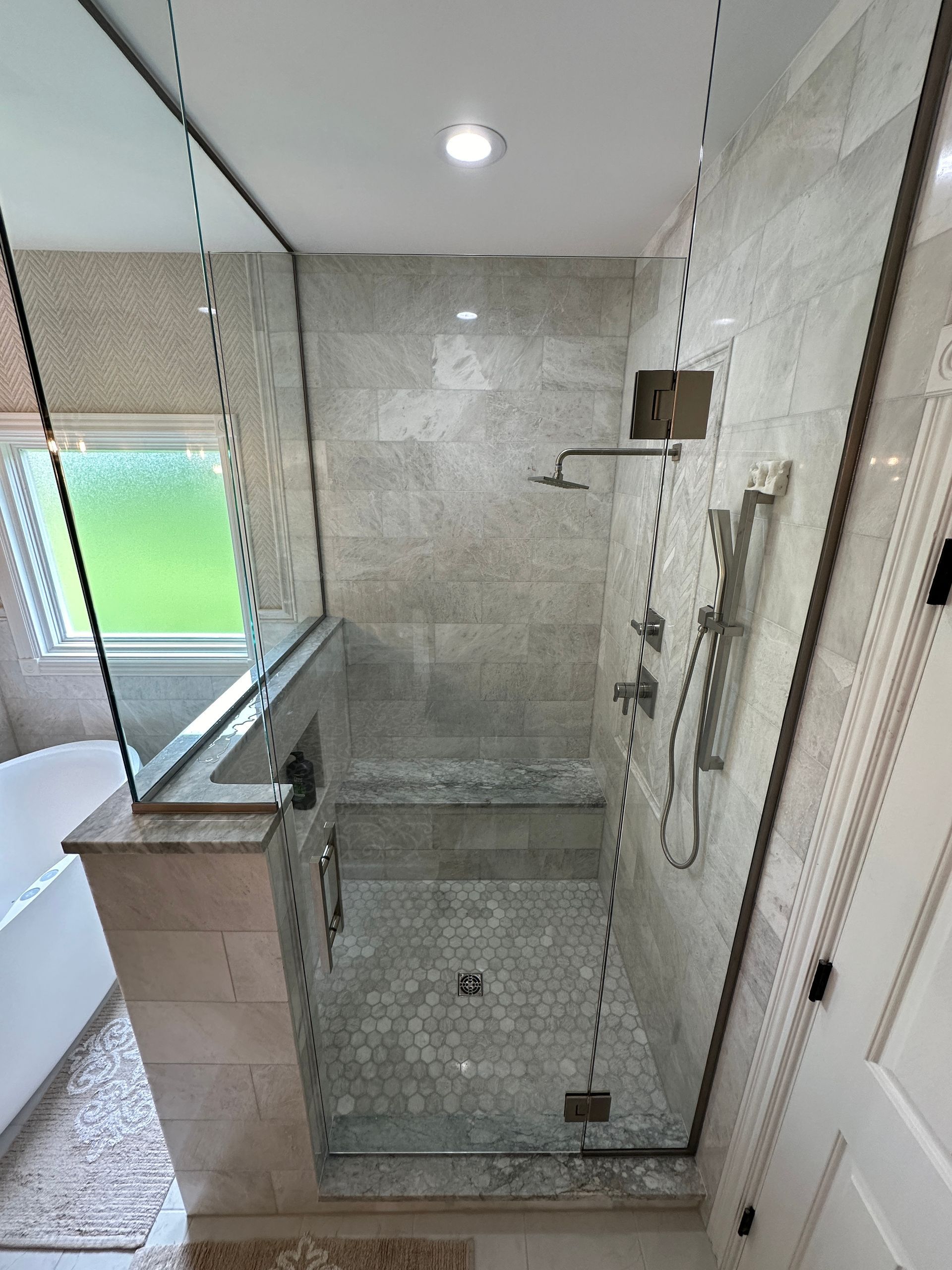 A bathroom with a walk in shower and a bathtub.
