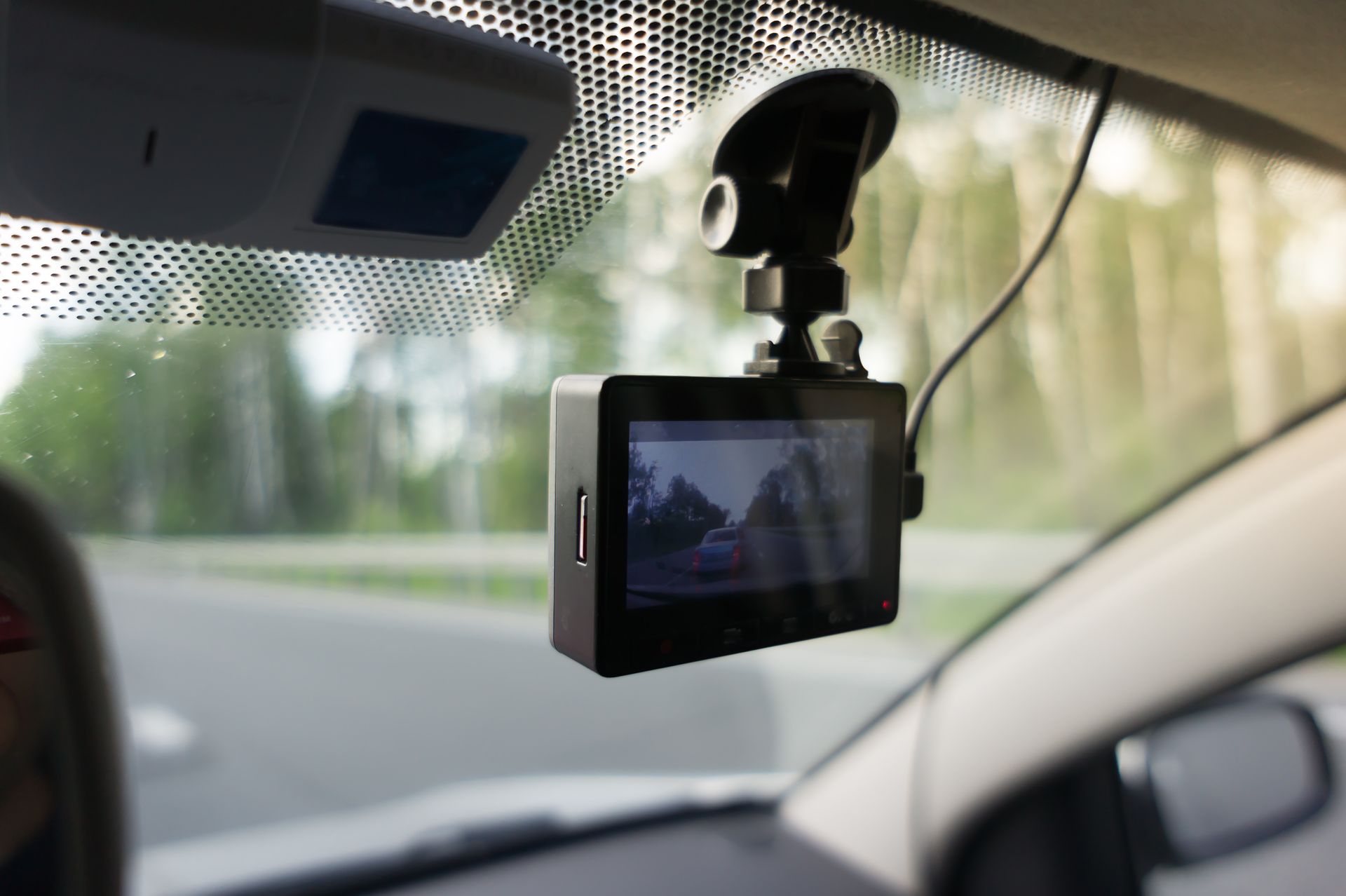 Dashboard camera mounted on a car windshield, filming the road ahead.