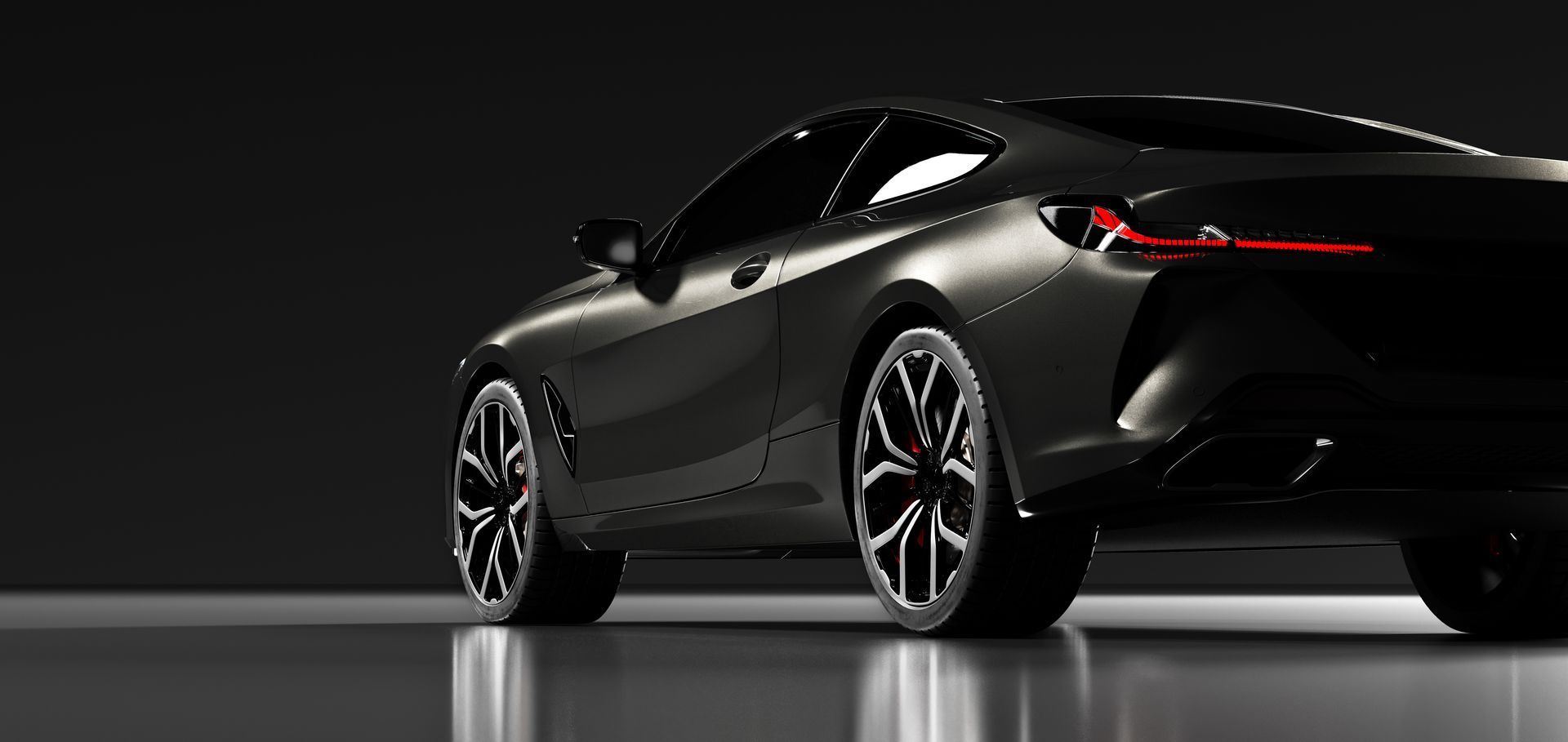 Black sports car on a dark studio background, shown from the rear three-quarter view.