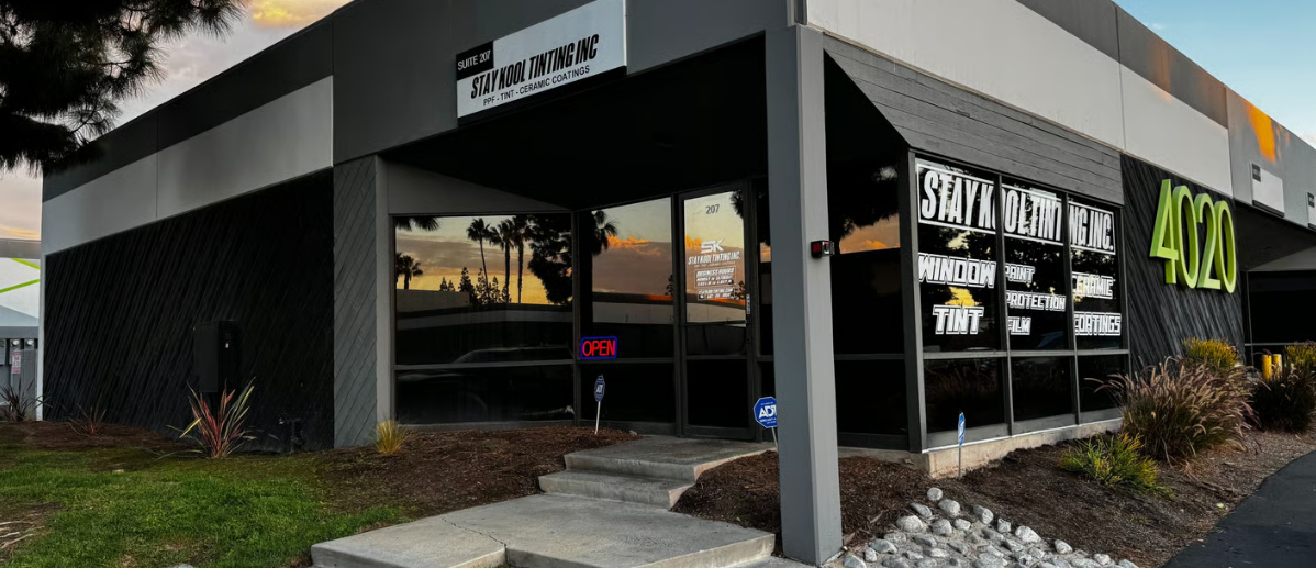 Modern storefront with black exterior, large windows, and neon signage at dusk Modern storefront with black exterior, large windows, and neon signage at dusk