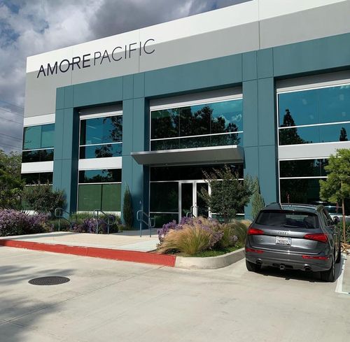 Black electric SUV parked in front of a white building with garage-style doors. Black electric SUV parked in front of a white building with garage-style doors.