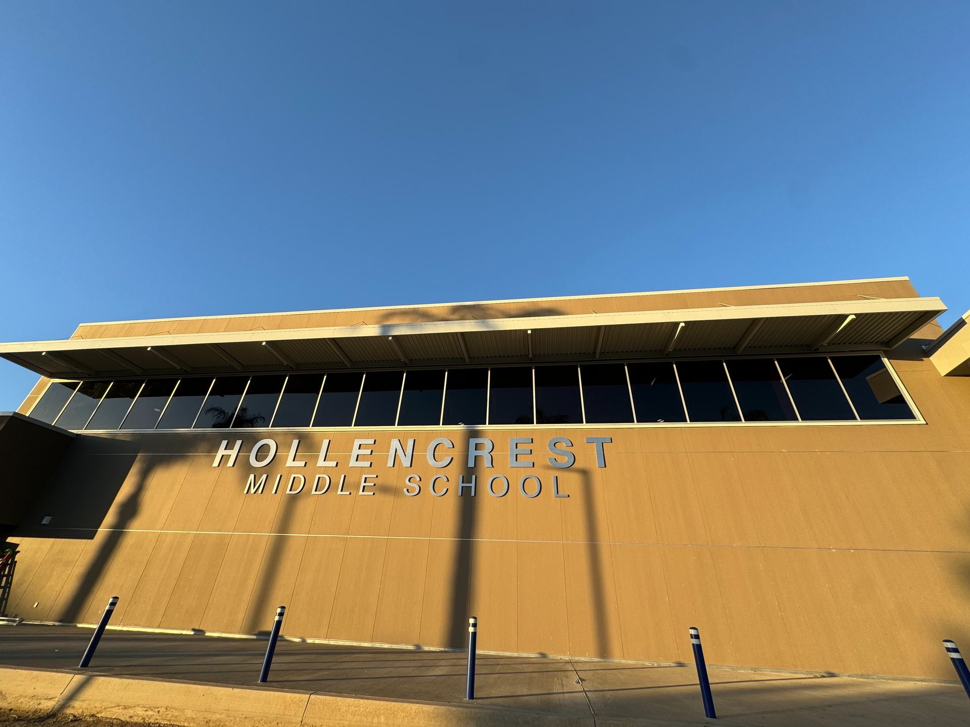 Hollingcrest building facade with large sign against a clear blue sky